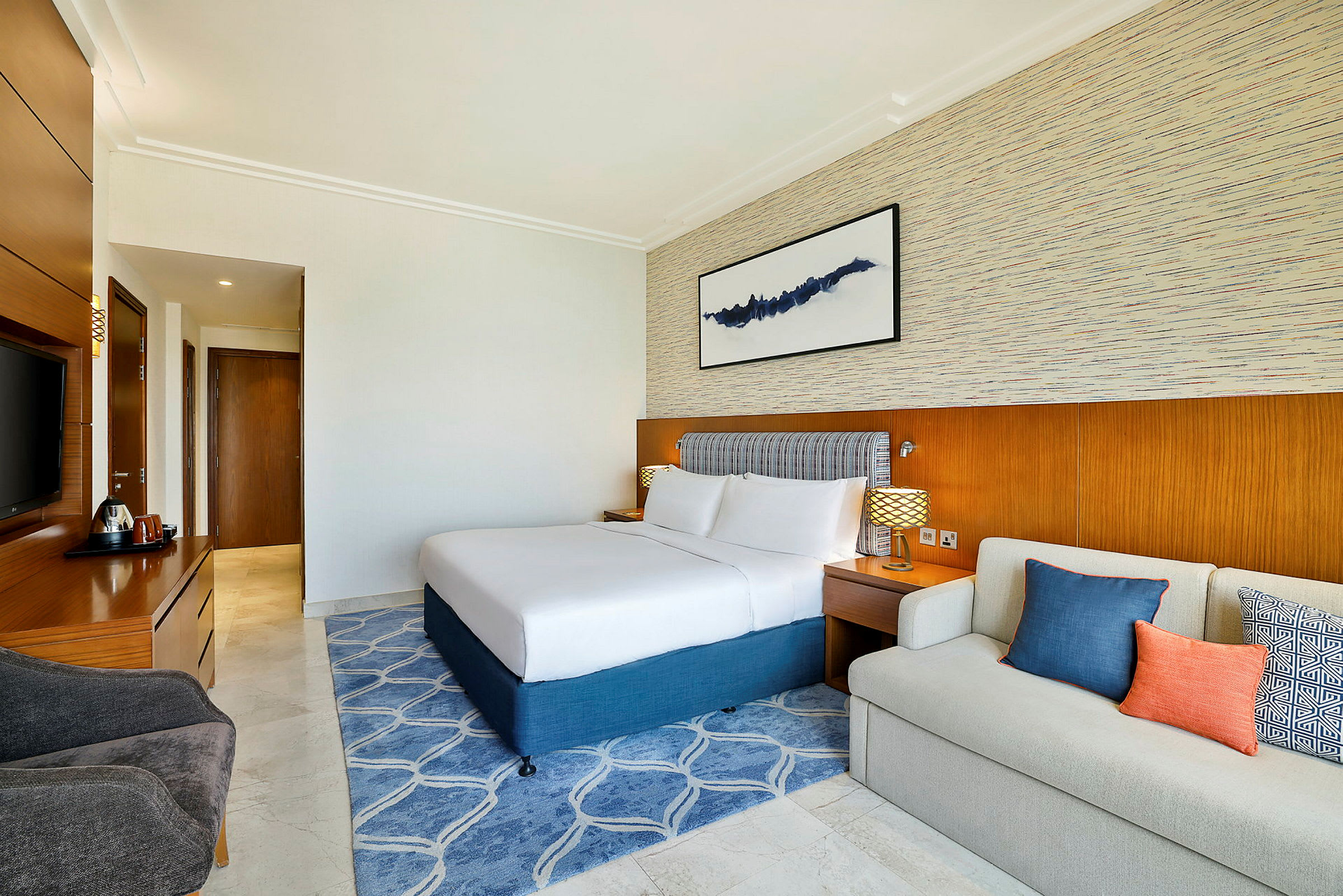 Hotellets rum med en dubbelsäng, en sittgrupp och möbler i en modern stil. (AI-genererad text)