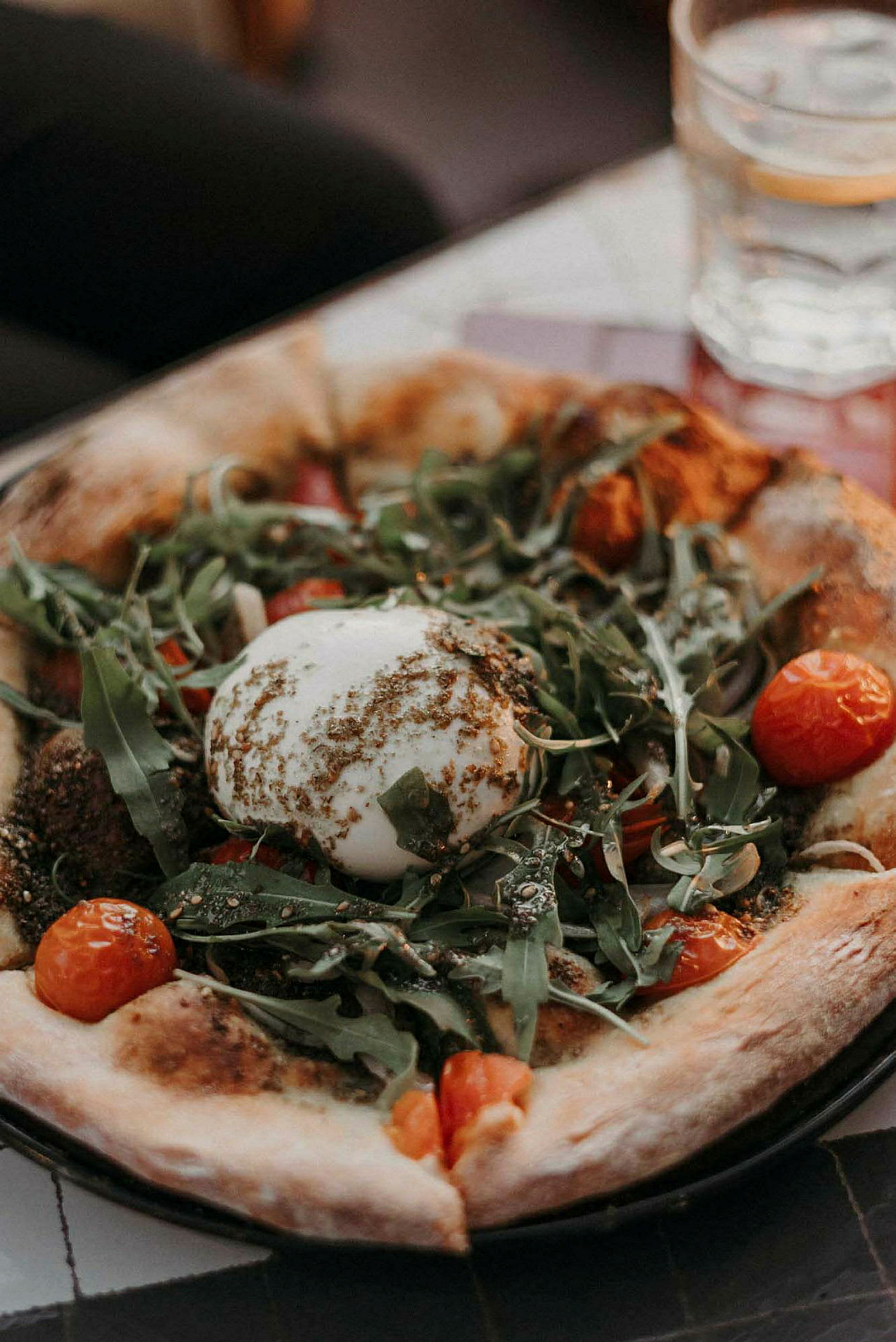 Pizza med burrataost, ruccola och körsbärstomater. (AI-genererad text)
