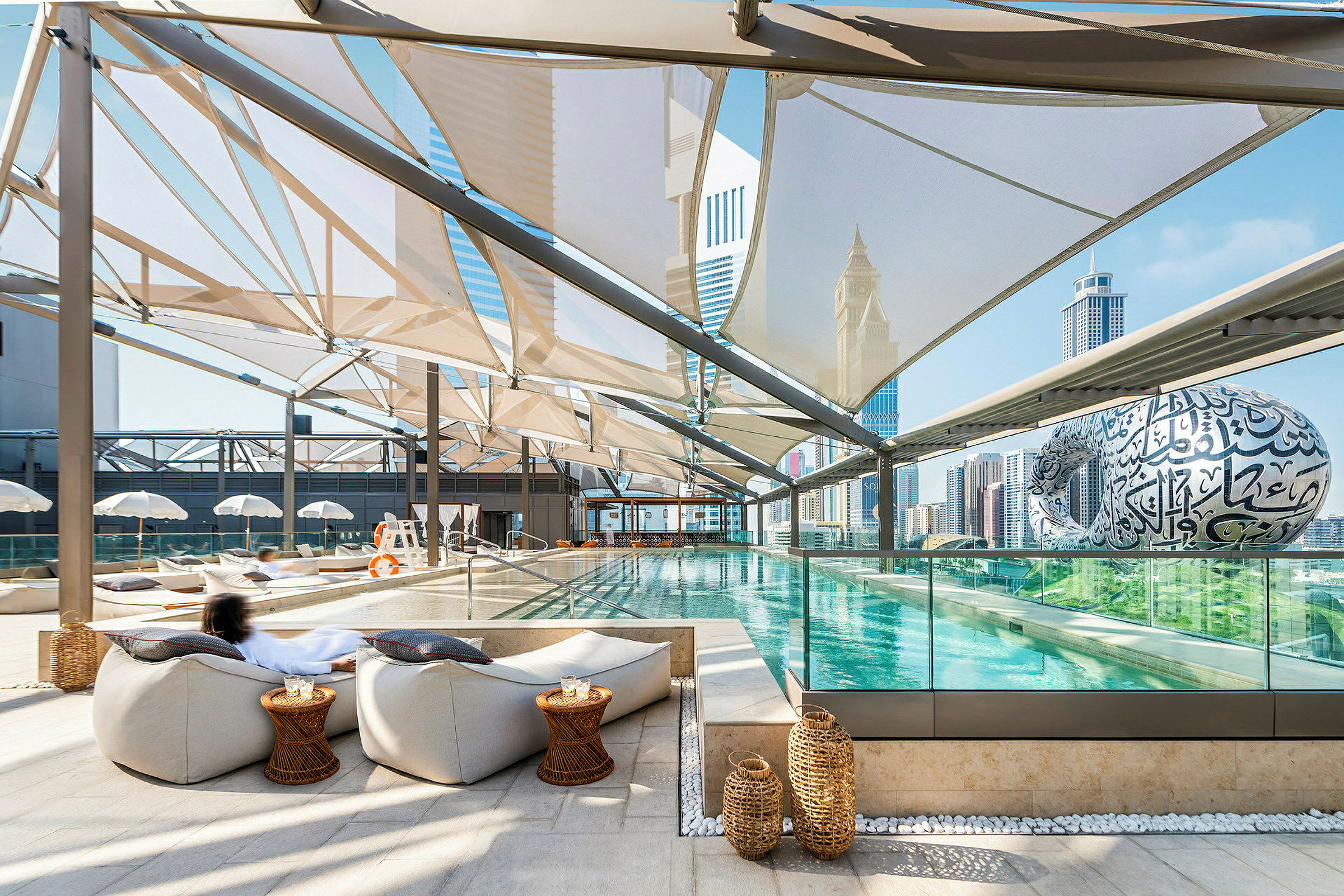 En modern utomhuspool med sittplatser och utsikt över stadens skyline. (AI-genererad text)