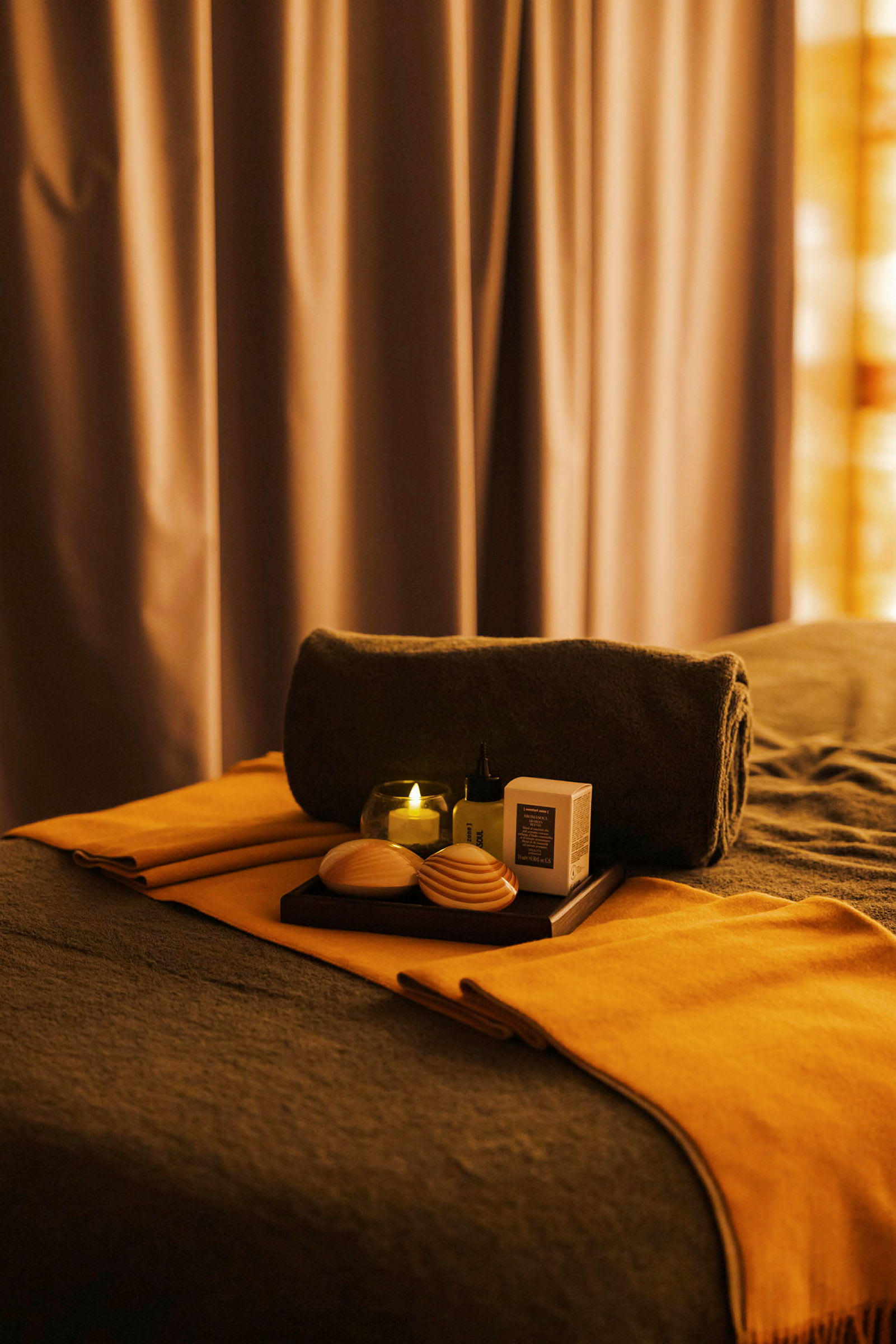 Spa-bord med handduk, ljus och massageverktyg. (AI-genererad text)