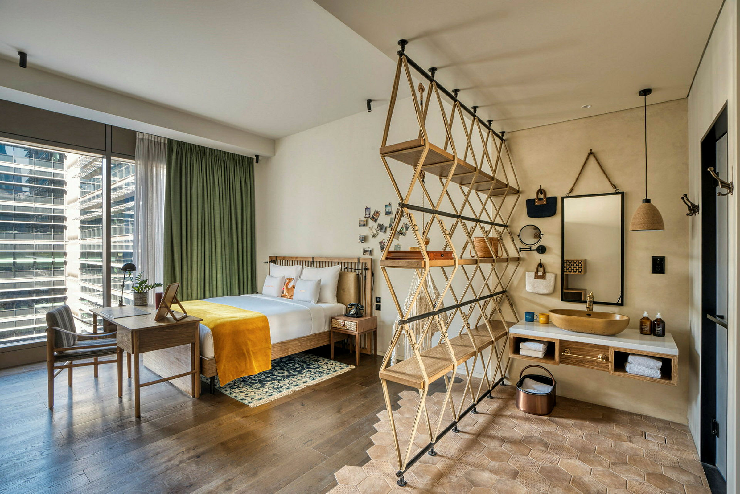 Ett modernt hotellrum med säng, skrivbord och öppen badrumsdesign. (AI-genererad text)