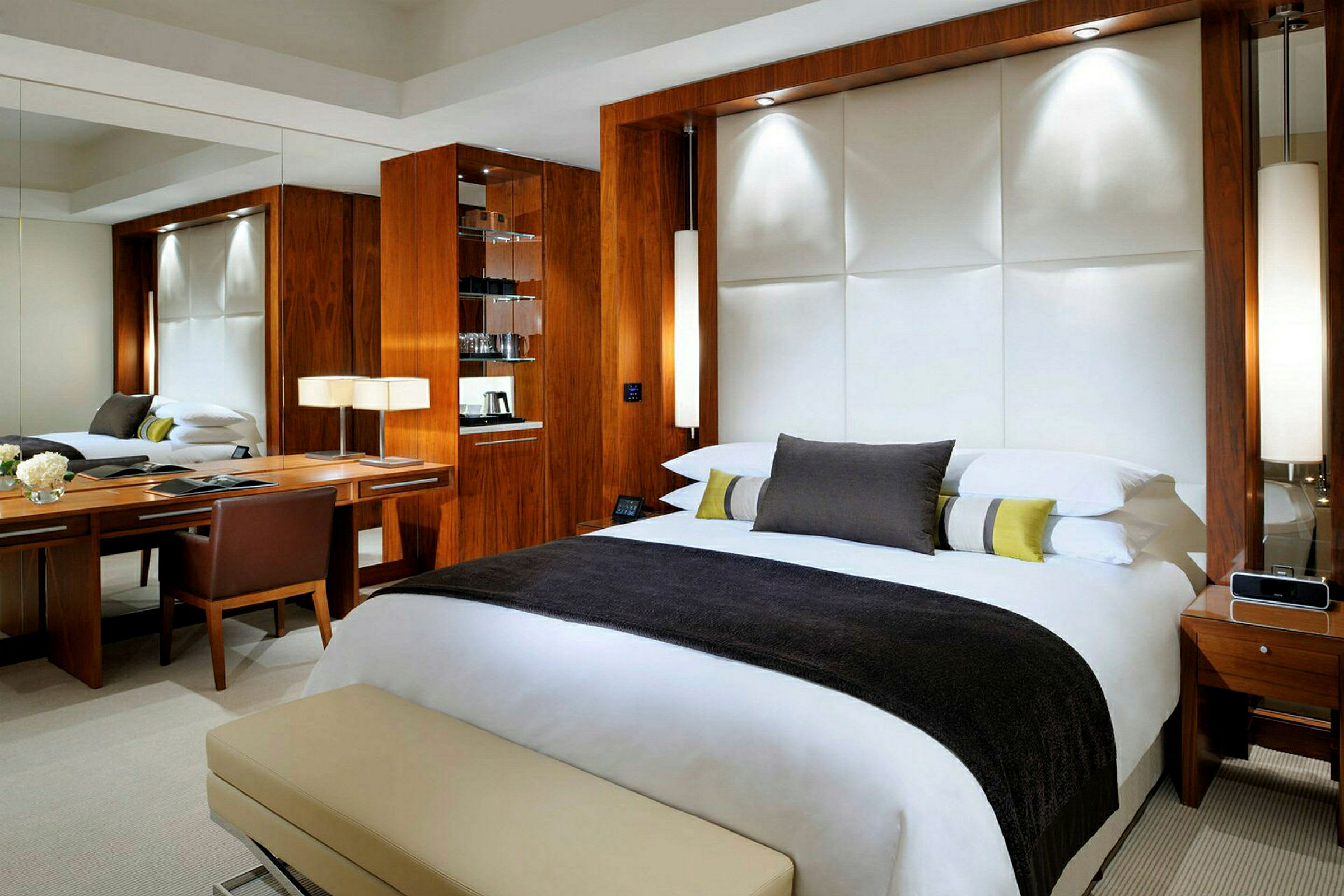 Ett modernt hotellrum med en stor säng, skrivbord och träpaneler. (AI-genererad text)