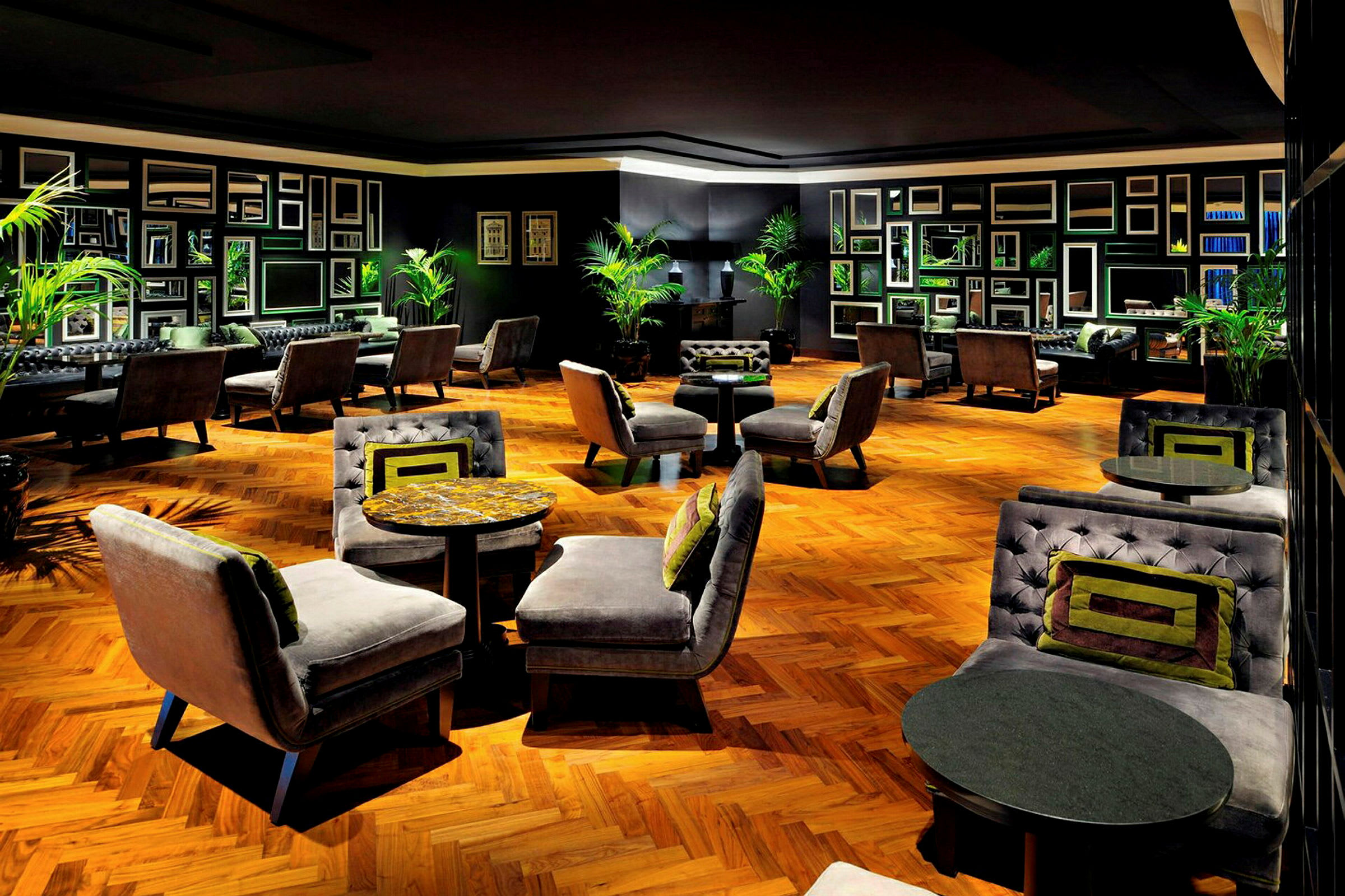 En stilfull hotellounge med eleganta fåtöljer och soffor kring små bord, på ett trägolv. (AI-genererad text)