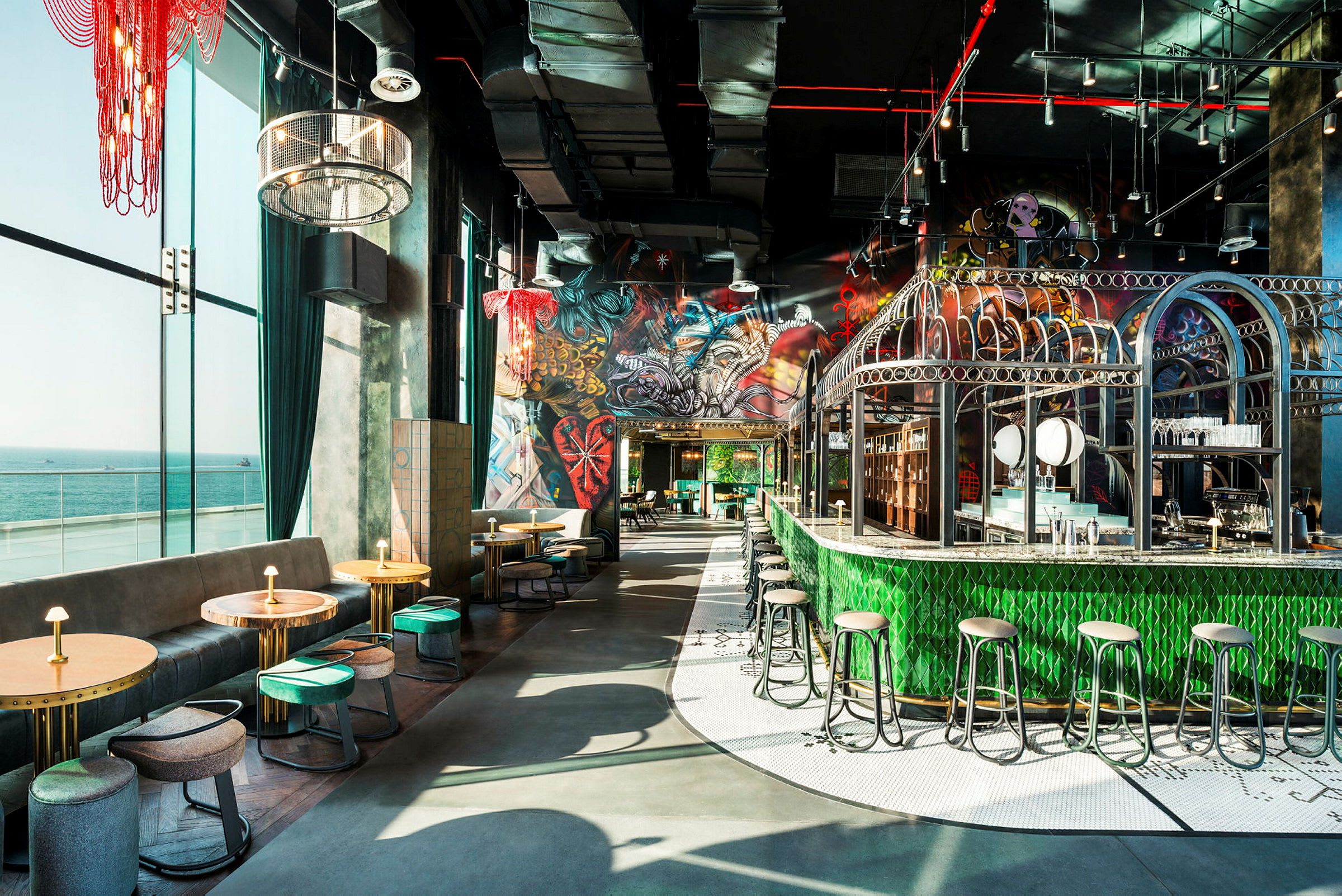 Interiör av en färgstark restaurang med sittplatser, bar och utsikt mot havet. (AI-genererad text)