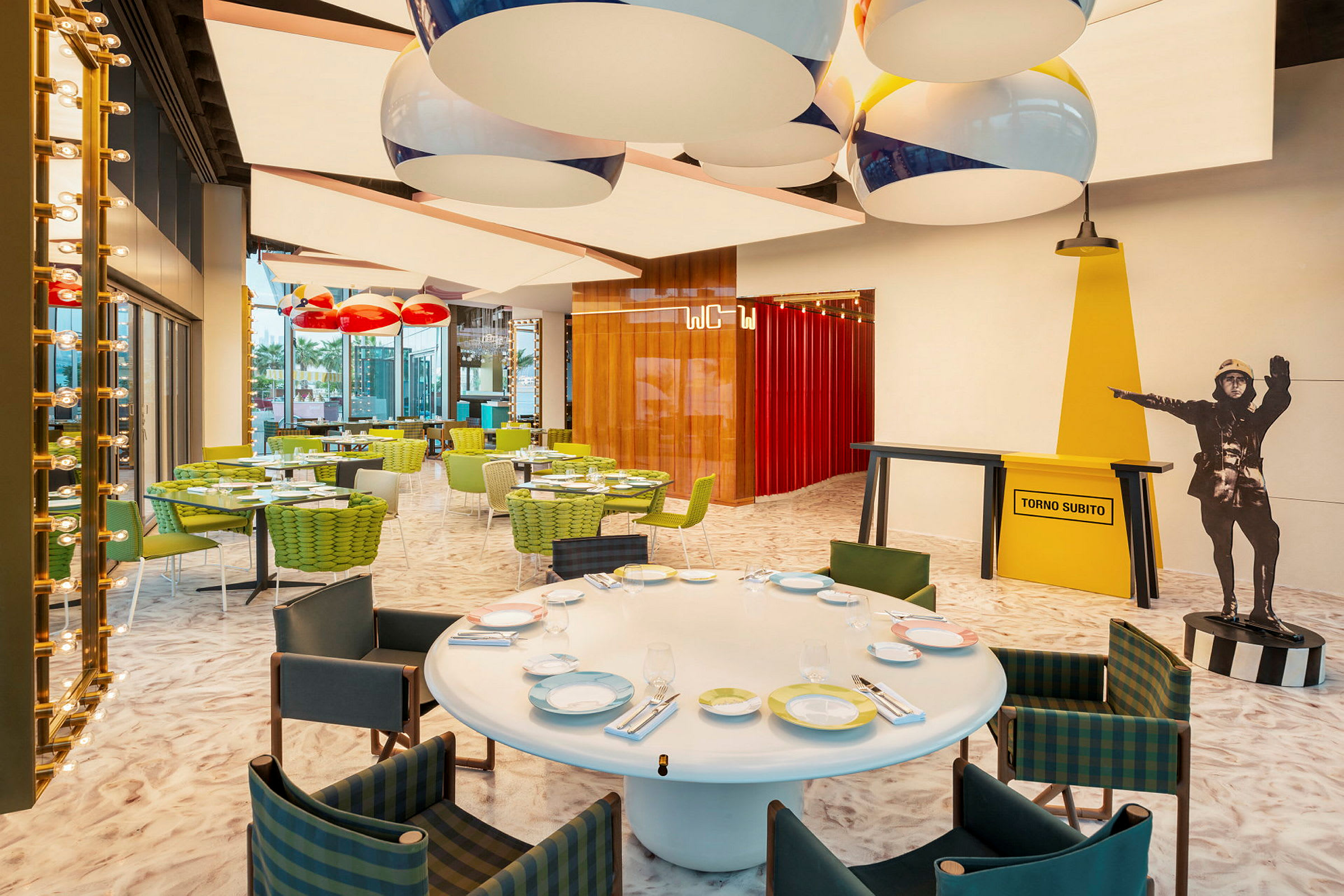 Interiörbild av en färgglad restaurang med sittplatser och dekorativa lampor. (AI-genererad text)