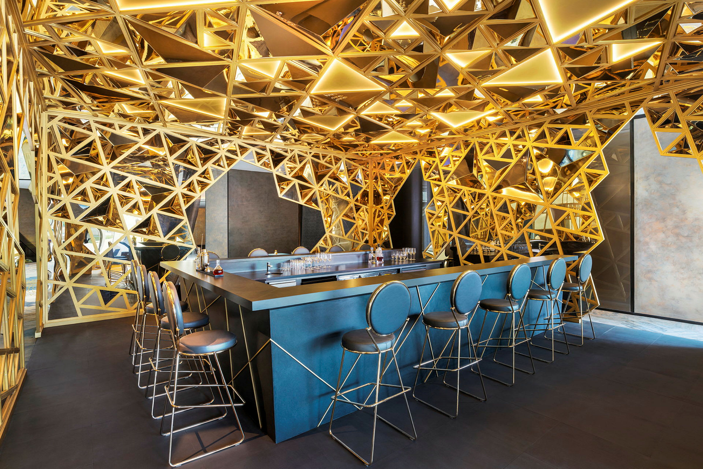 En modern bar med en geometrisk, guldfärgad inredning. (AI-genererad text)