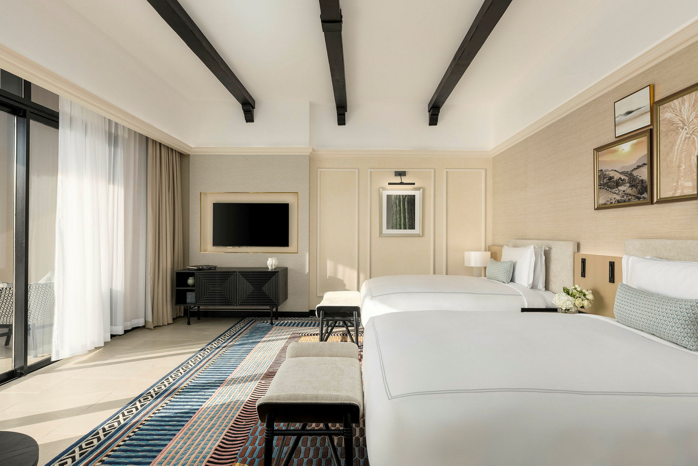 Ett modernt hotellrum med två enkelsängar, en TV på väggen och ett fönster med gardiner. (AI-genererad text)