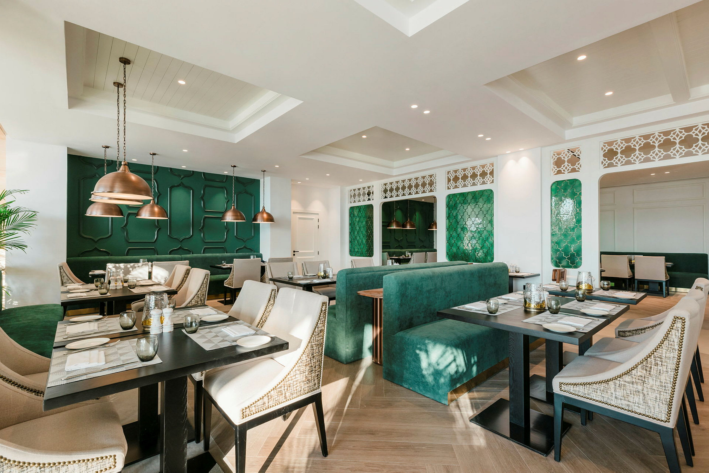 Bild på en elegant restaurang med gröna dekorativa väggpaneler och moderna möbler. (AI-genererad text)