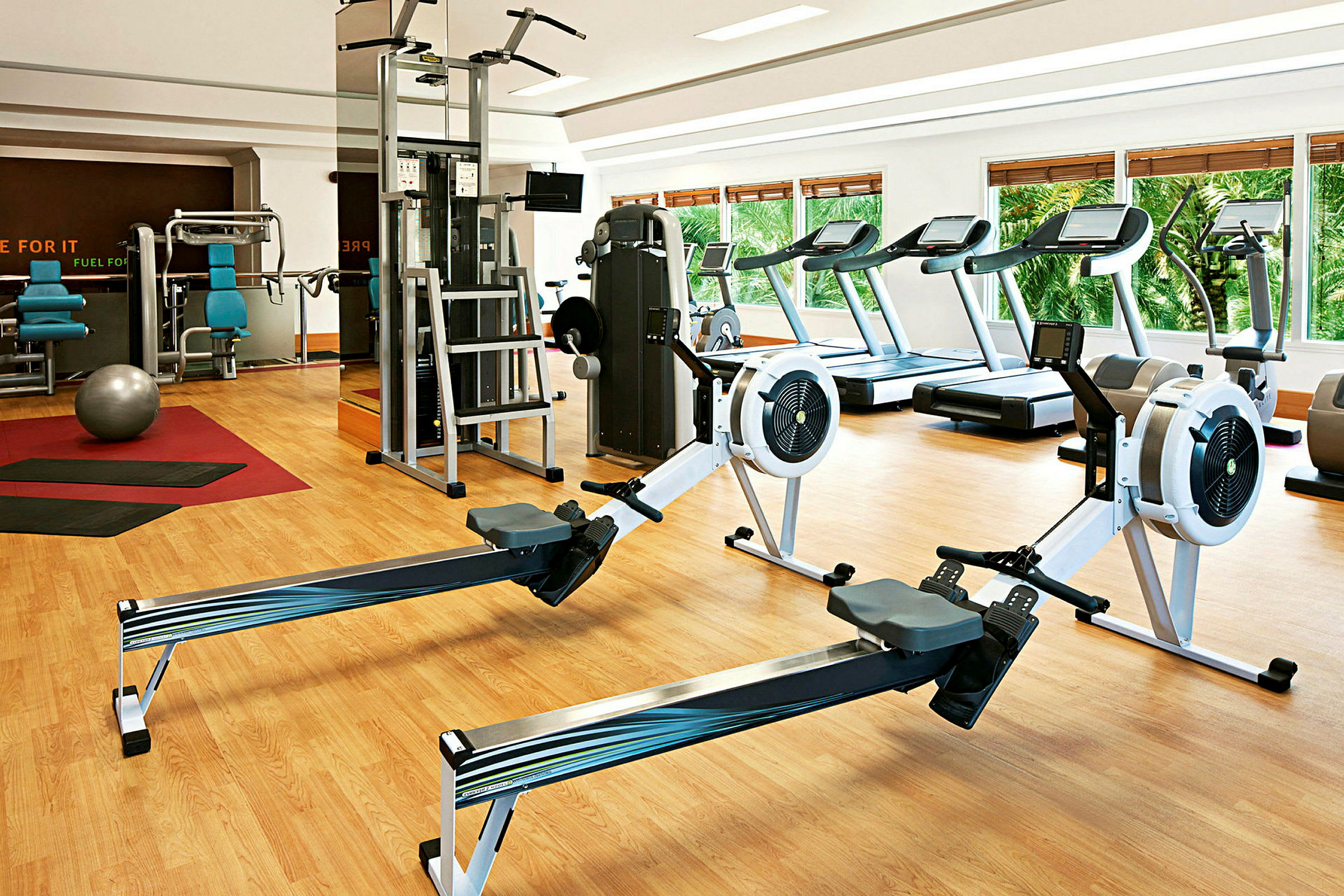 Ett gym med träningsmaskiner såsom löpband, roddmaskiner, och styrketräningutrustning. (AI-genererad text)