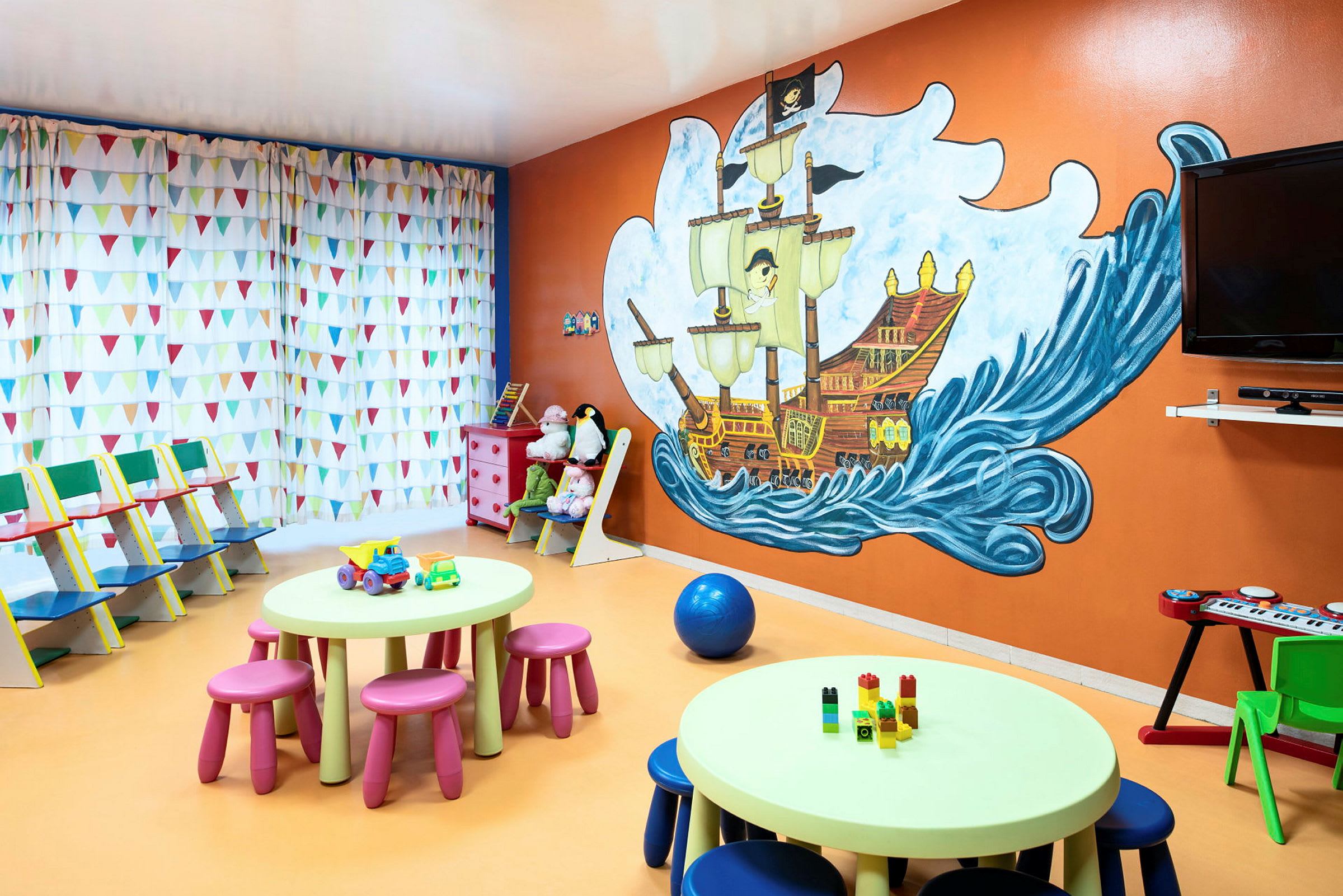 Lekrum med piratmural och färgglada möbler. (AI-genererad text)