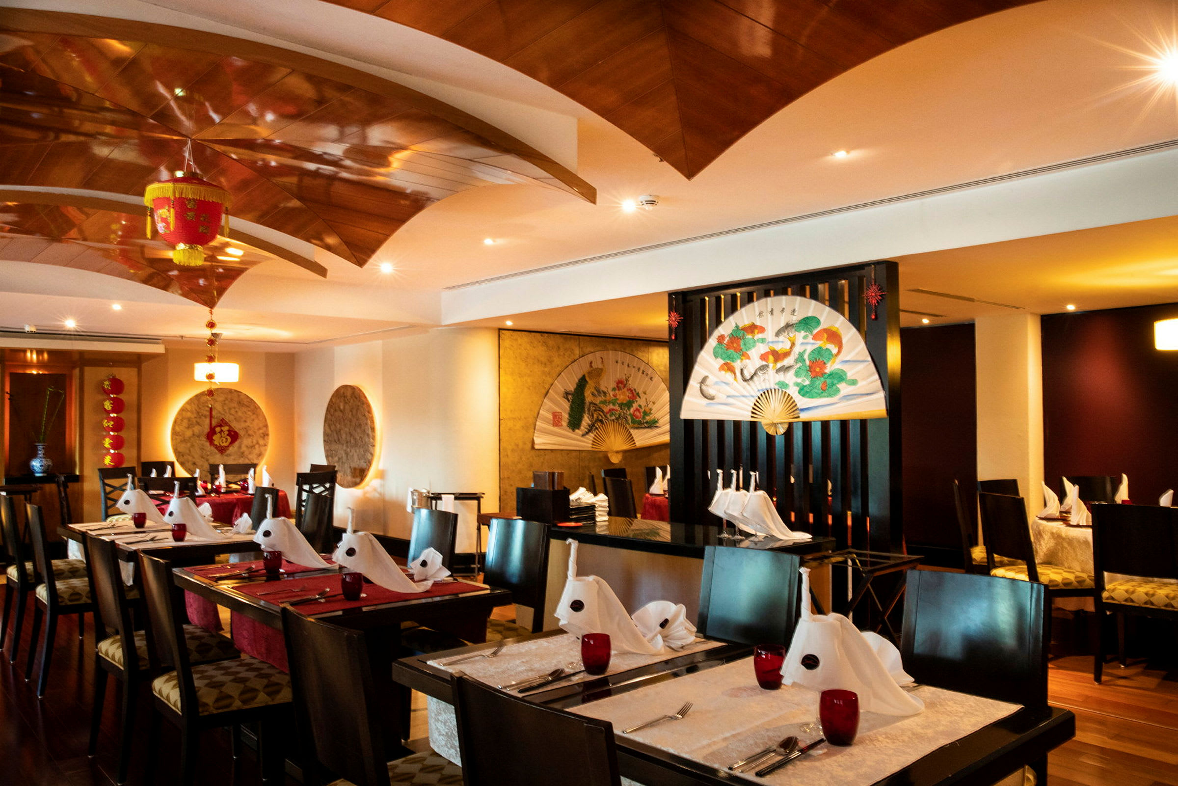 Elegant restaurang med asiatiskt inspirerade dekorationer och dukade bord. (AI-genererad text)