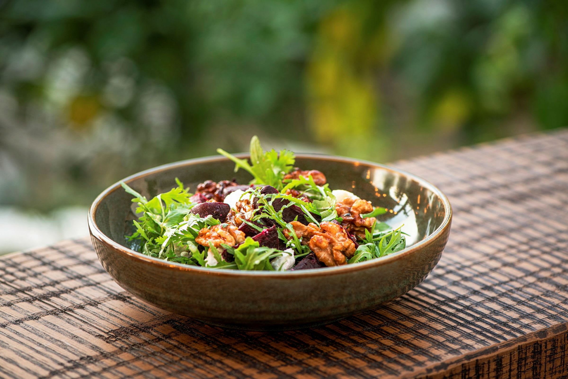 En sallad innehållande grönsaker och nötter serverad i en skål. (AI-genererad text)
