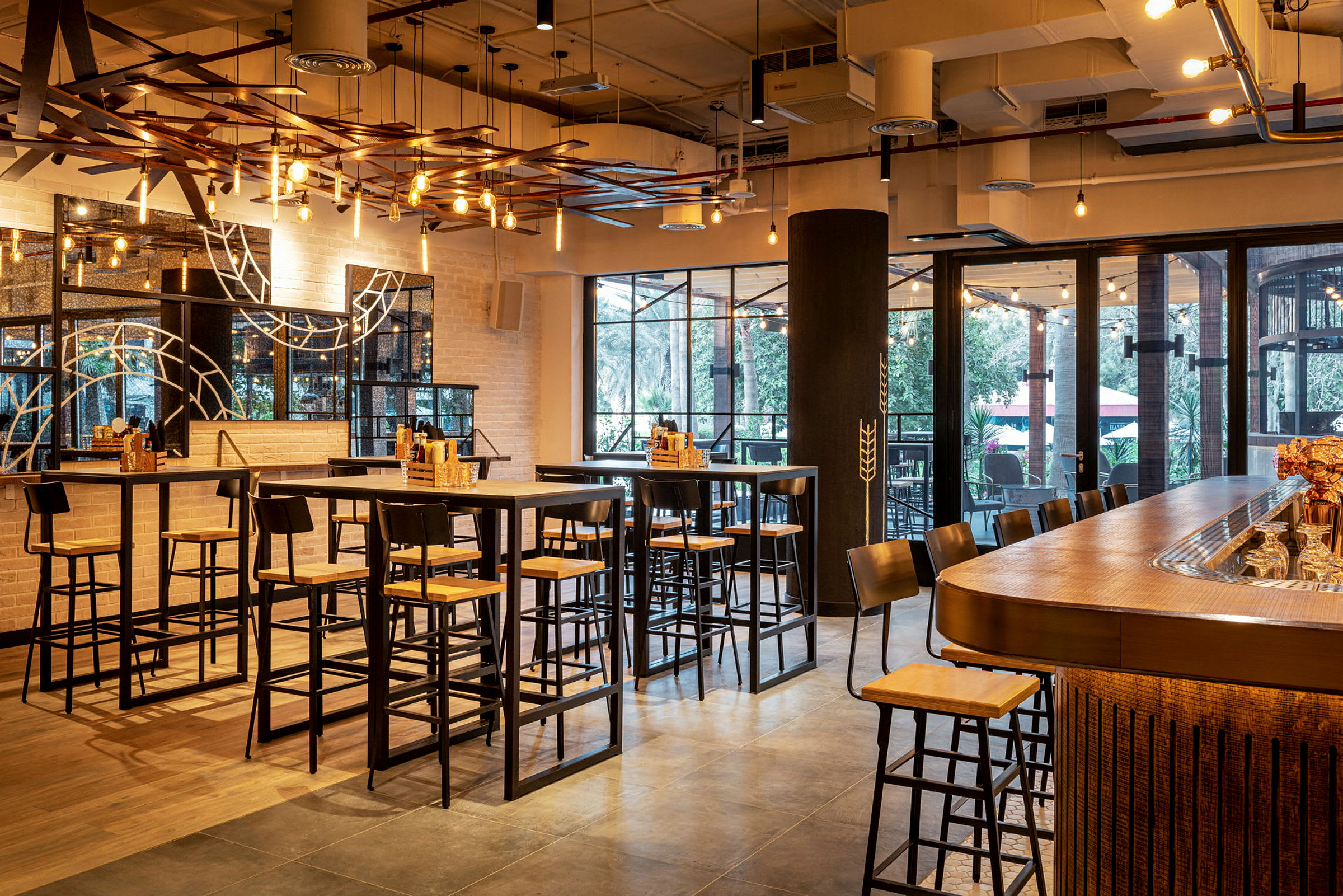 En inomhusrestaurang med högbord och barstolar under modern belysning. (AI-genererad text)