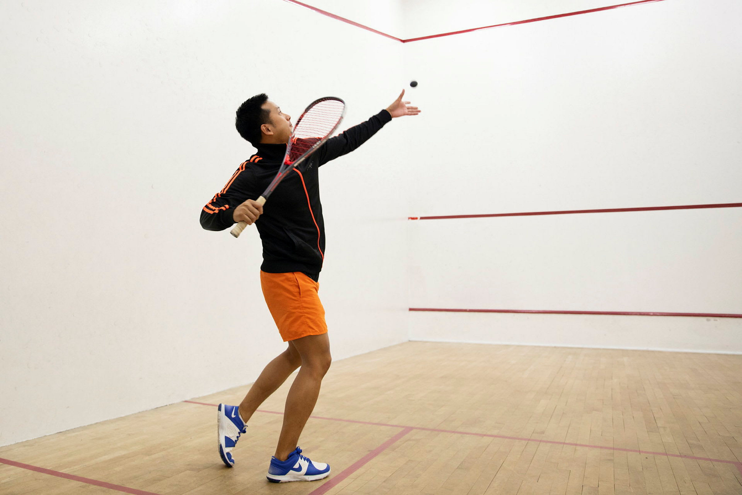 Person spelar squash och gör en serve på banan. (AI-genererad text)