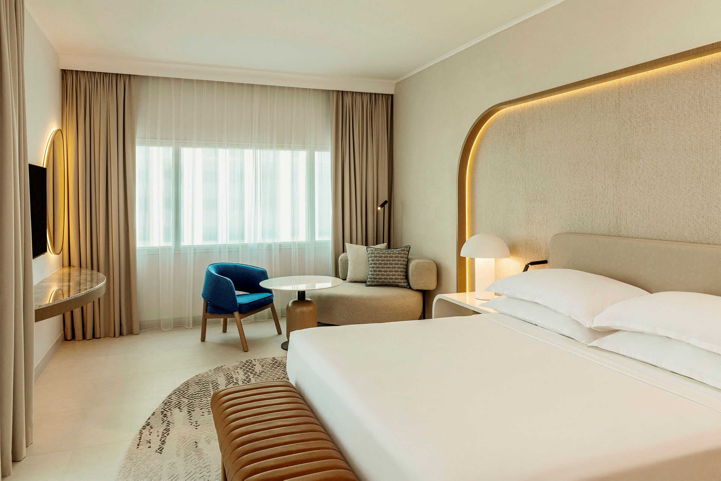 Ett modernt hotellrum med en stor säng, sittgrupp och skrivbord. (AI-genererad text)