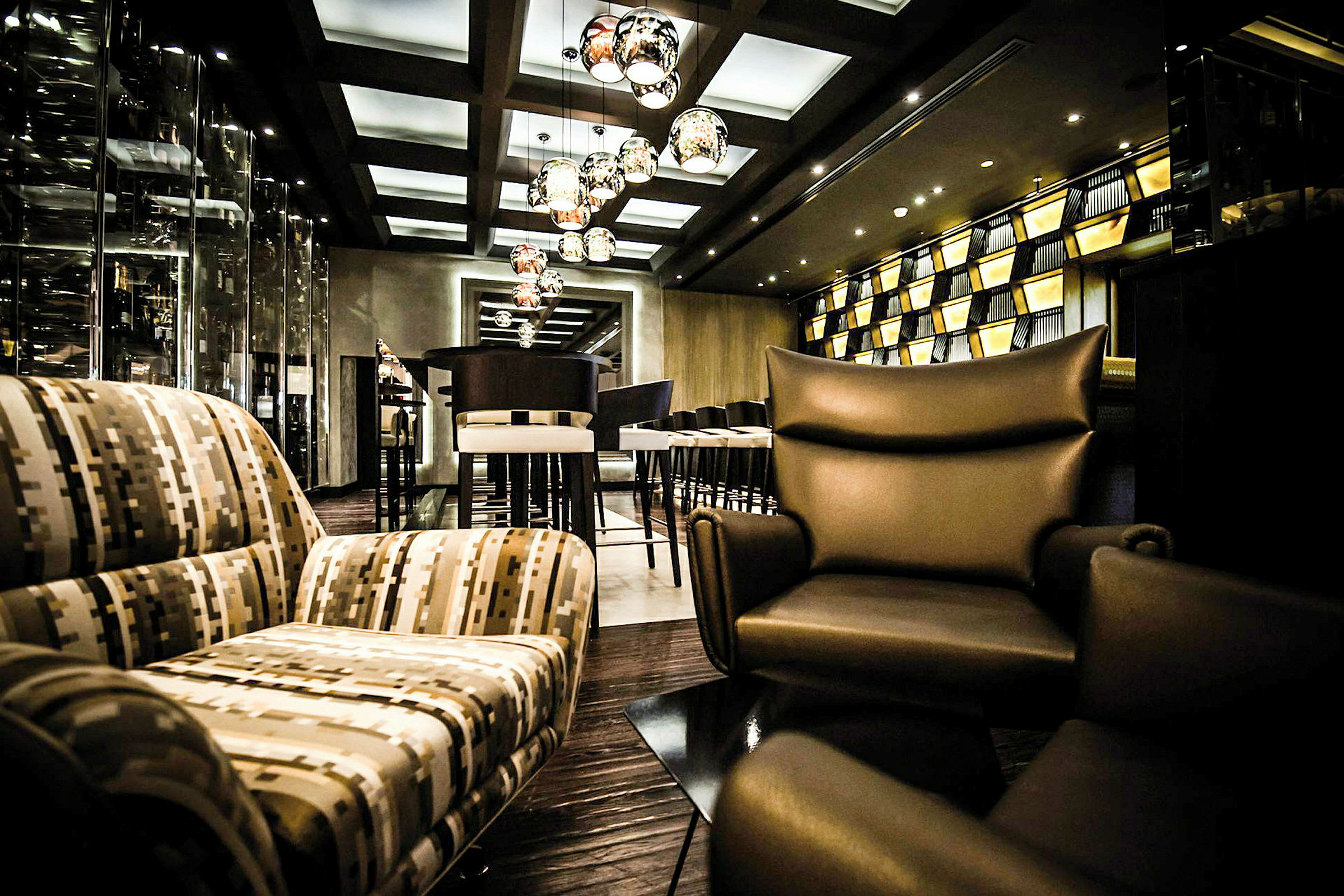 Bild av en stilfullt inredd lounge med moderna sittmöbler, hängande lampor och en välvårdad atmosfär. (AI-genererad text)