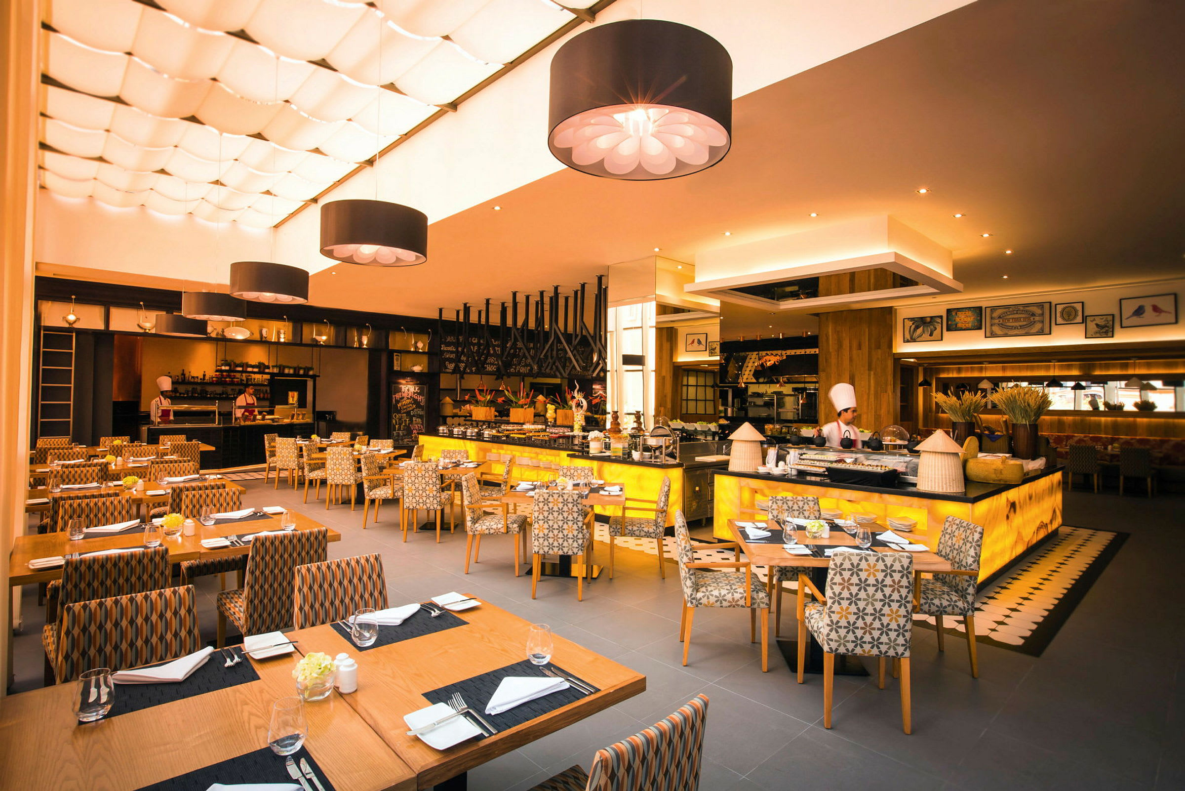 En restaurang med modern inredning, sittgrupper och ett öppet kök. (AI-genererad text)