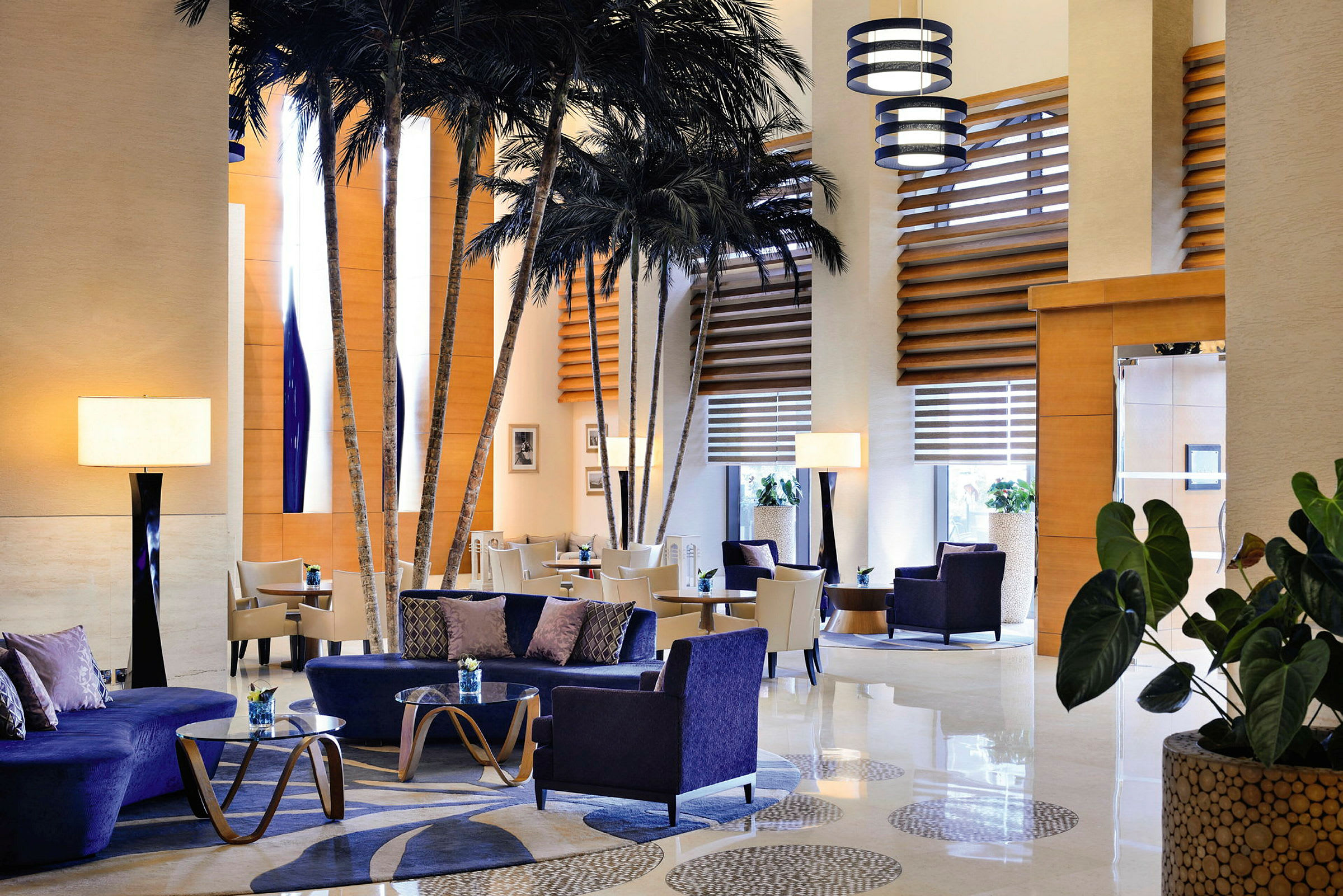 Lyxigt inrett hotellobbymiljö med bekväma sittmöbler och dekorativa palmer. (AI-genererad text)