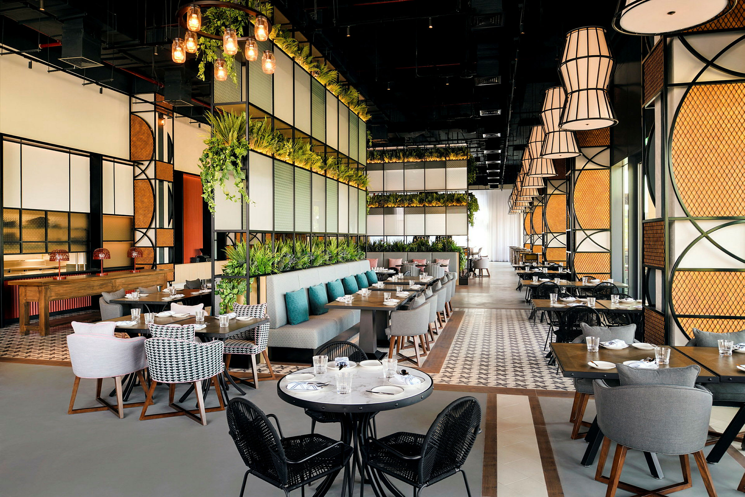 En modern restaurang med stora fönster, gröna växter och eleganta sittplatser. (AI-genererad text)