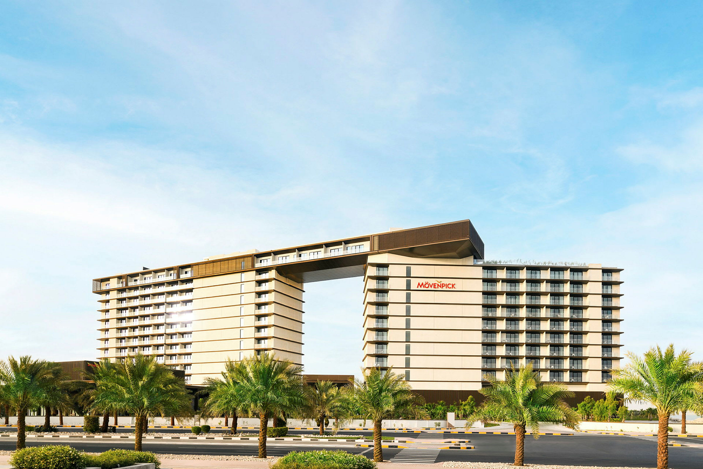 Hotellbyggnad med en modern design och palmer i förgrunden. (AI-genererad text)