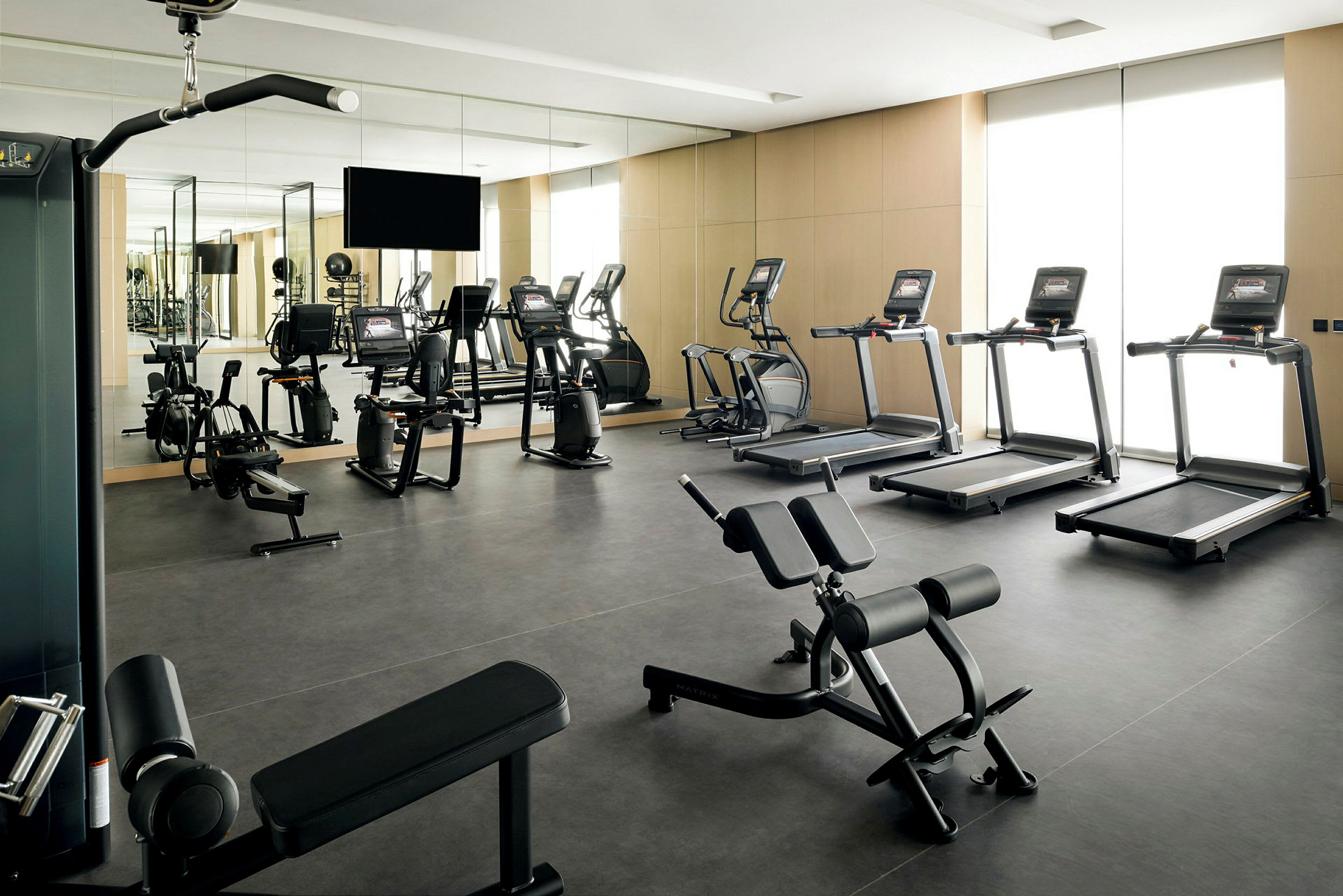 Ett gym med olika träningsmaskiner och speglar på väggarna. (AI-genererad text)