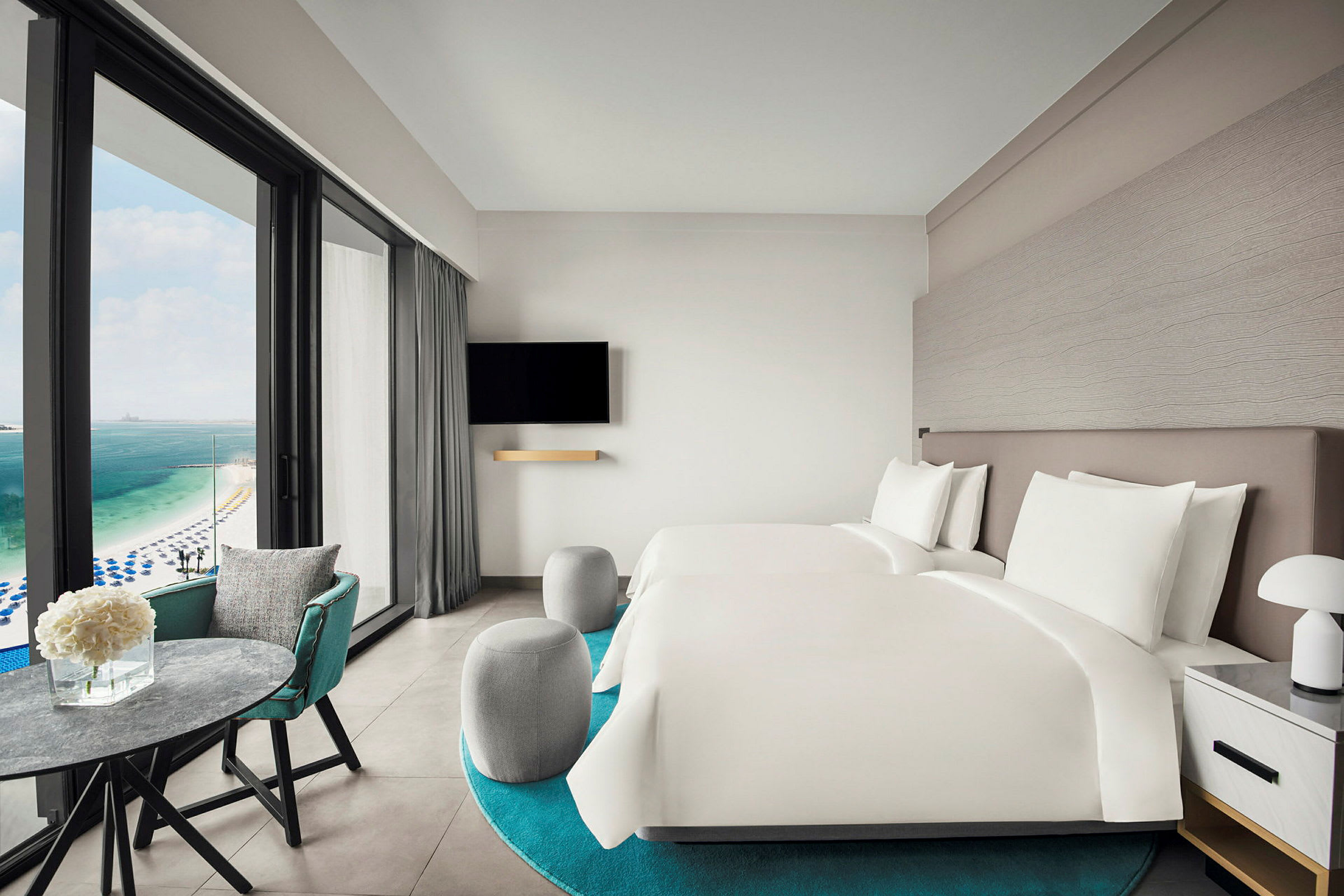 Hotellrum med två sängar och utsikt över havet. (AI-genererad text)
