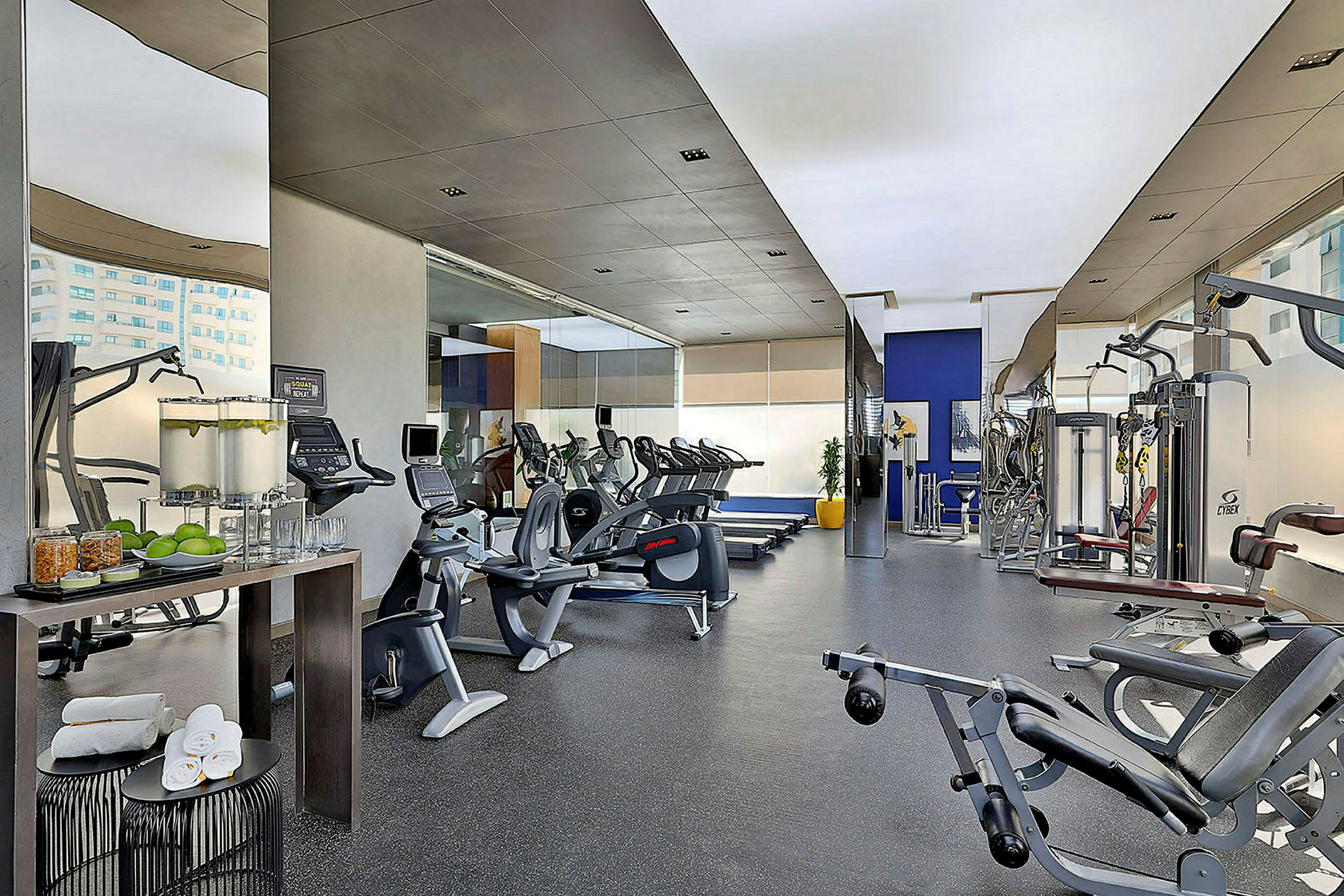 Ett gym med olika träningsmaskiner och en vattenstation. (AI-genererad text)