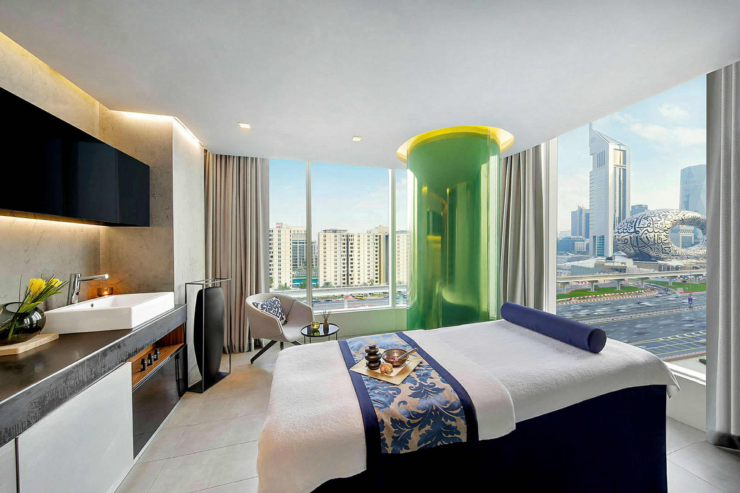 Rum med massagebänk, stora fönster med utsikt över Dubai. Inredning i modern stil. (AI-genererad text)