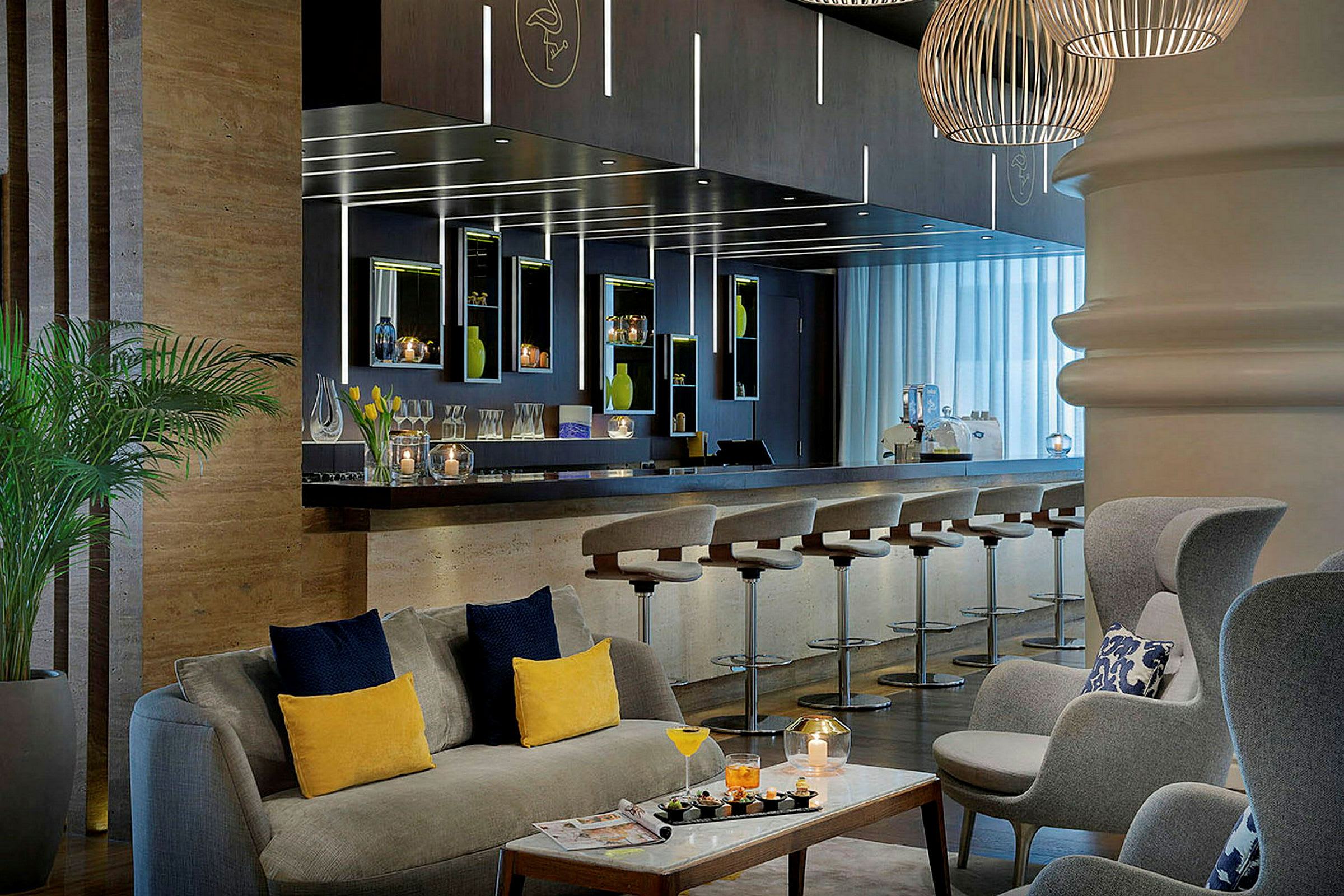 Ett välkomnande hotellounge med en bar, några stolar vid bardisken samt bekväma sittgrupper. (AI-genererad text)