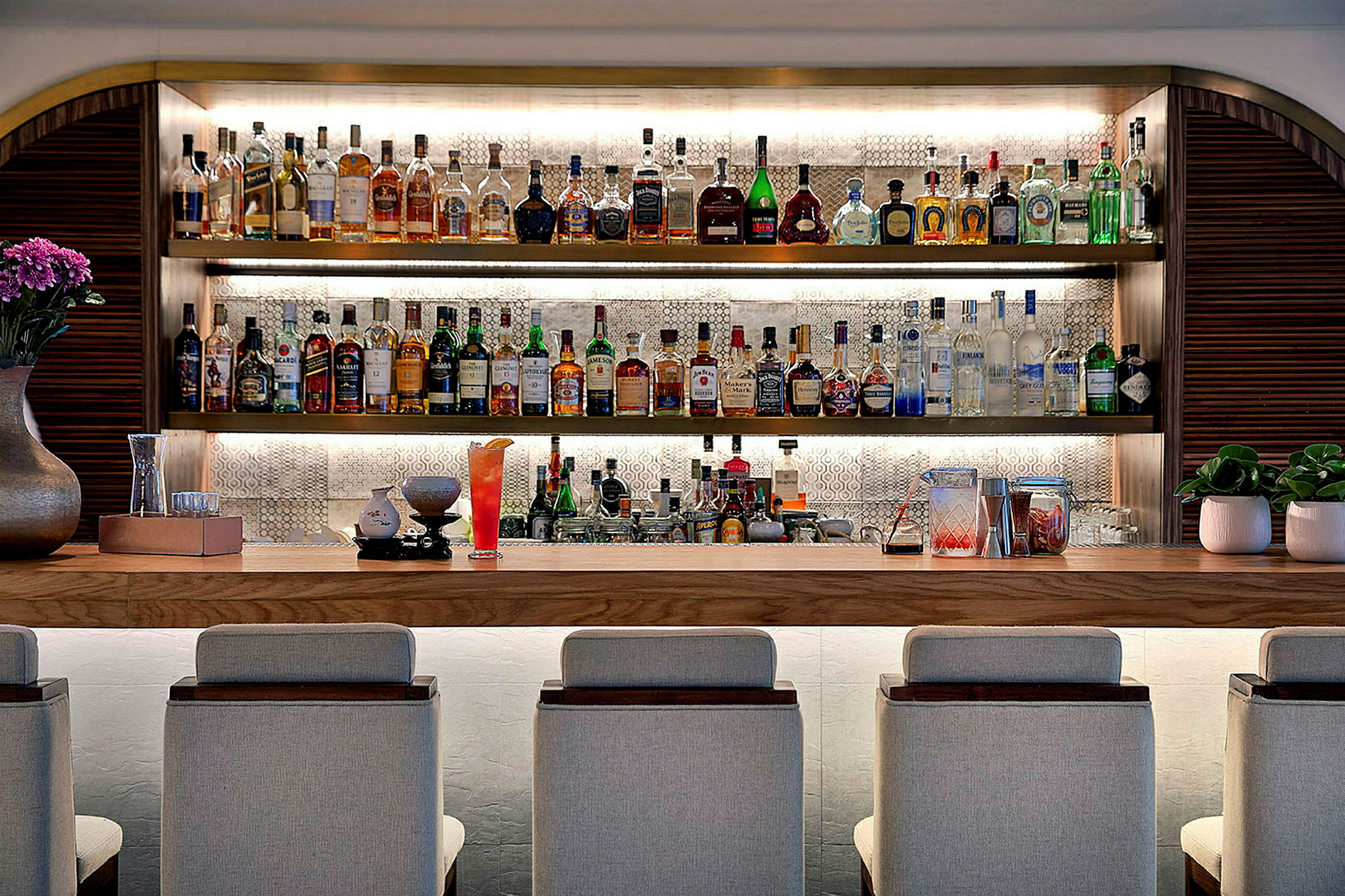 En välfylld bardisk med sittplatser, spritflaskor och dekorationer. (AI-genererad text)