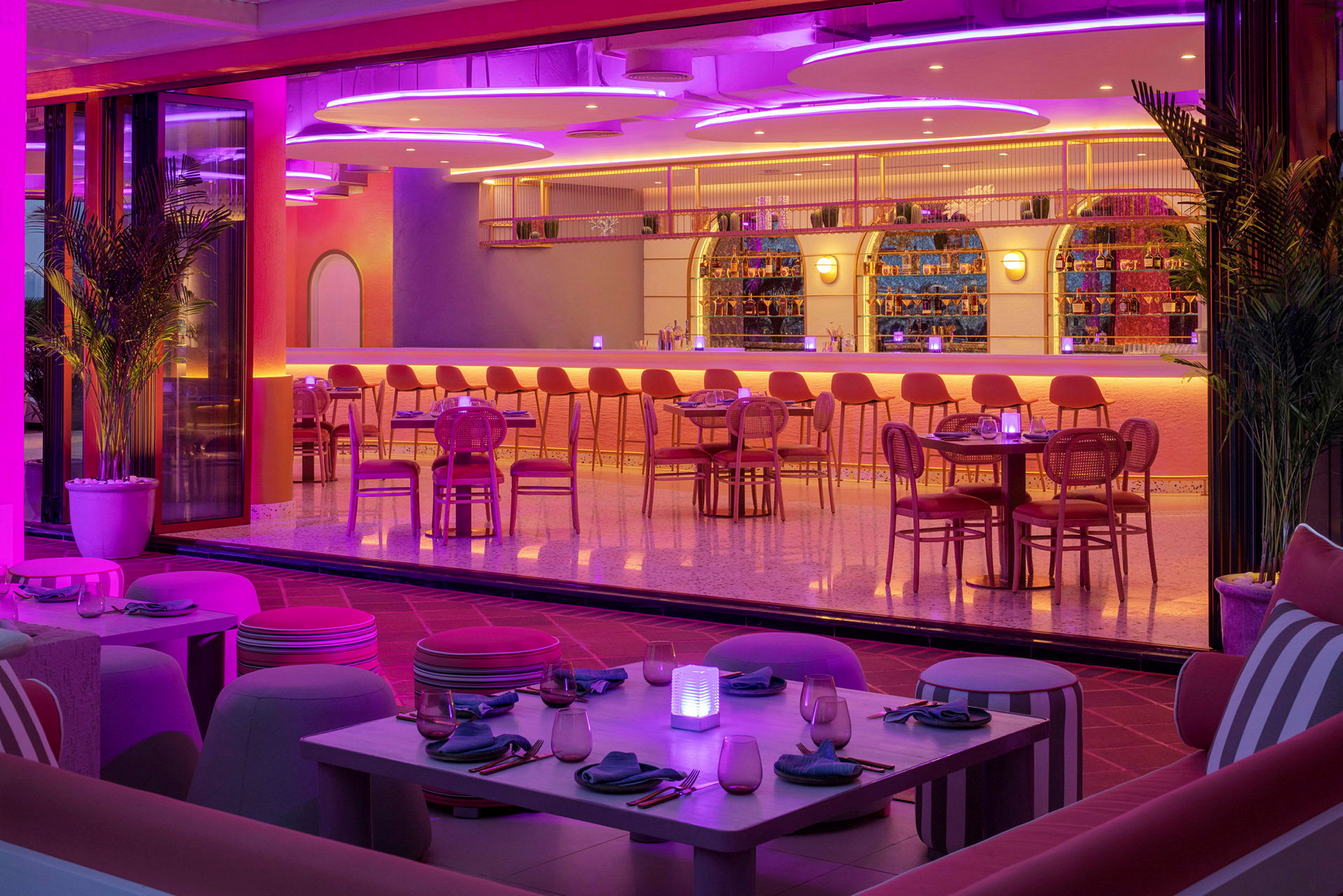 En modern bar och restaurang med färgglad belysning och stilren inredning. (AI-genererad text)