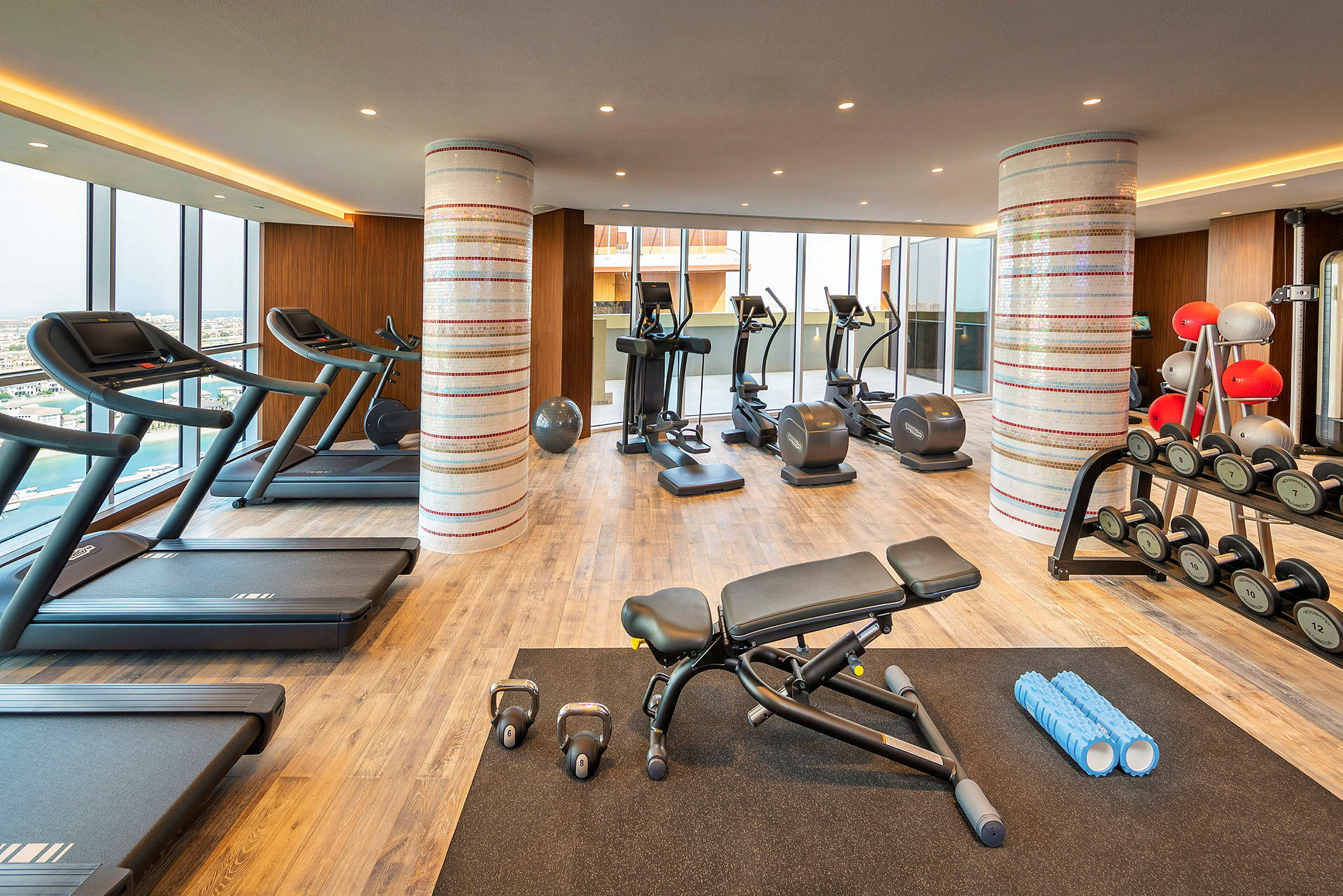 Ett gym med träningsutrustning, inklusive löpband, träningscyklar, vikter och andra redskap. (AI-genererad text)