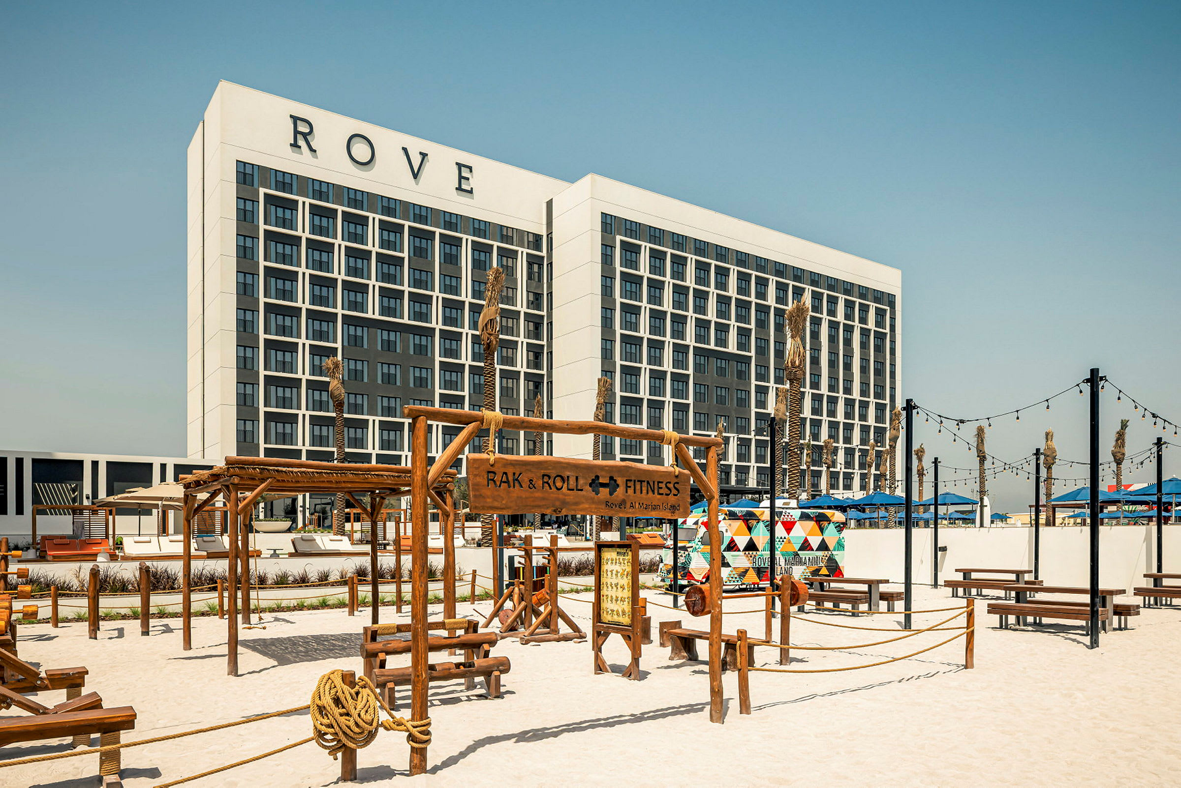 Bild av en hotellbyggnad med skylten Rove, framför ett utomhusgym och sandområde. (AI-genererad text)