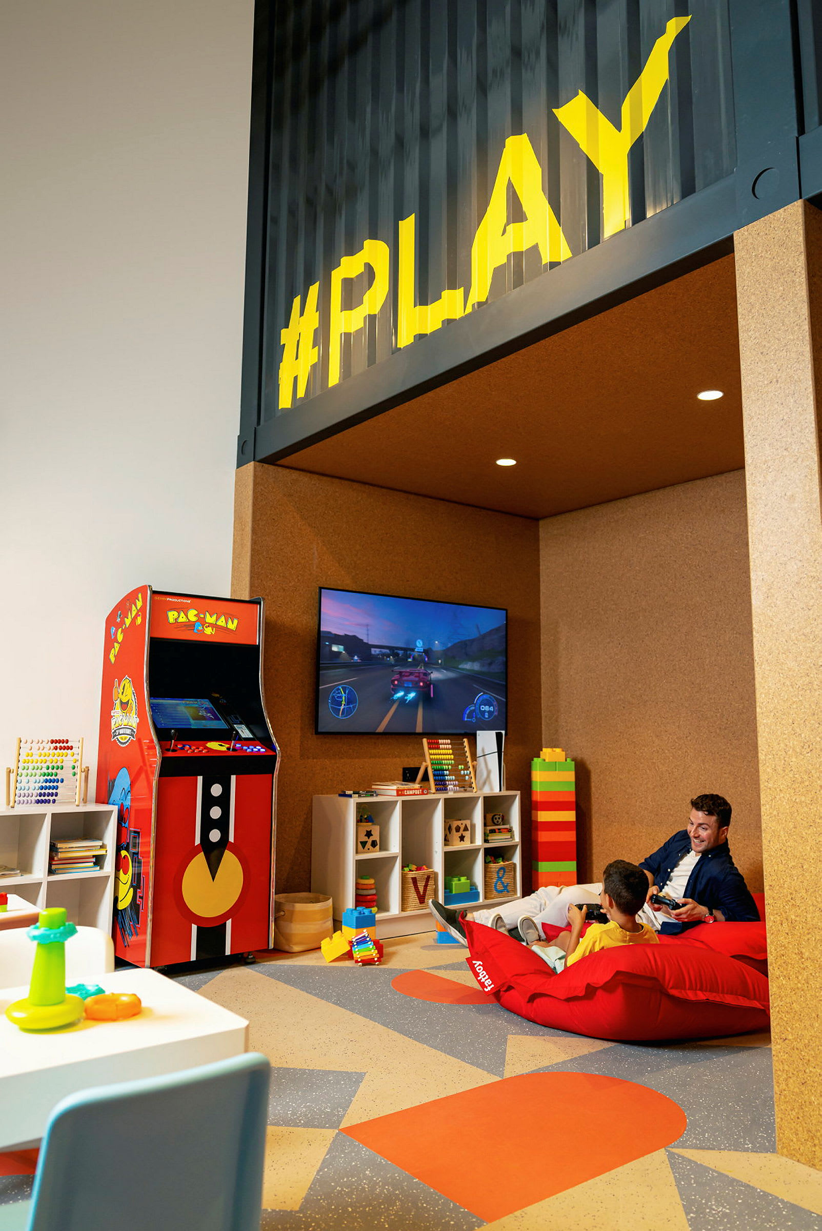 Lekrum med spelhörna som inkluderar arkadspel och TV-spel. (AI-genererad text)
