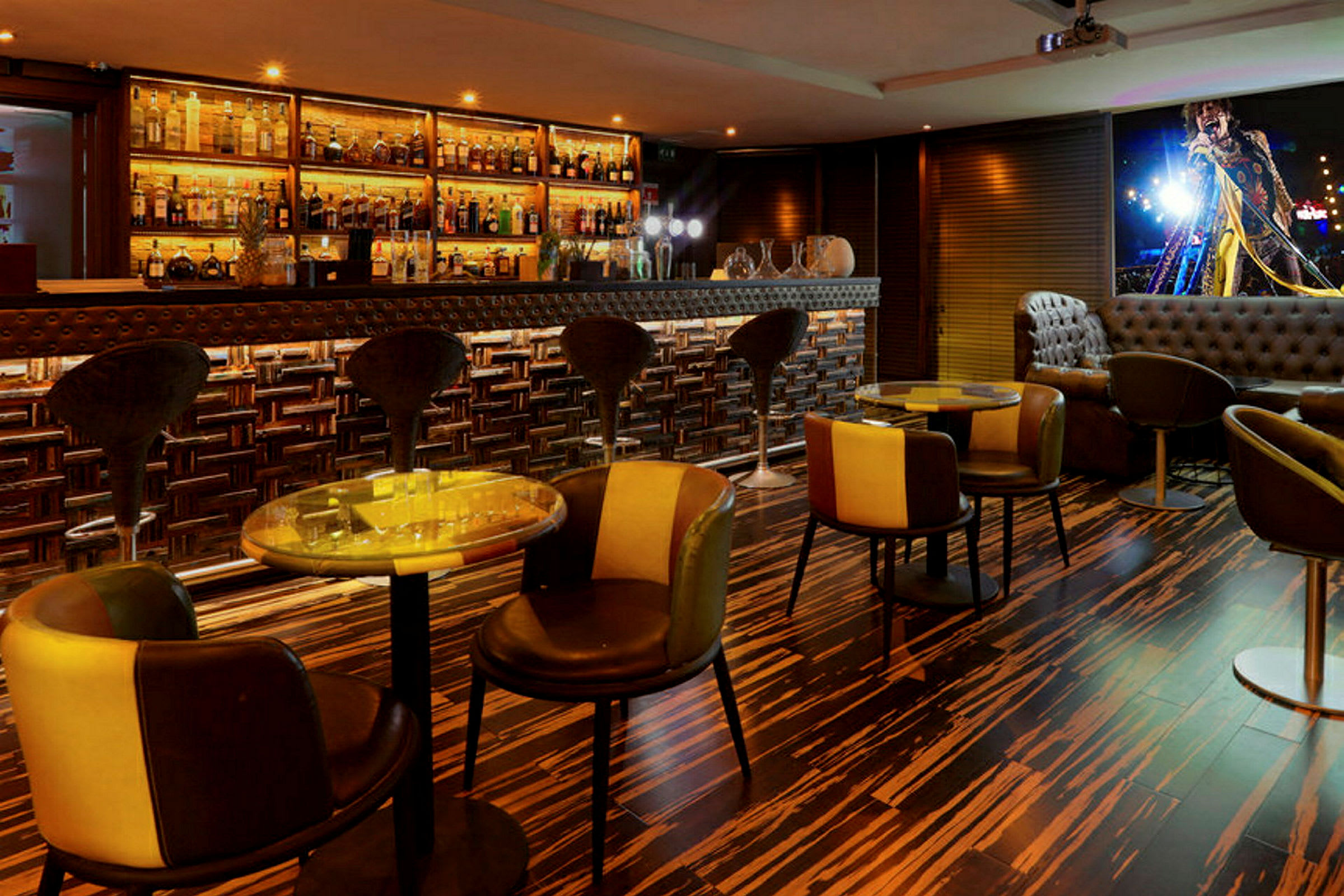 En interiör av en modern bar med höga stolar vid en bardisk och små bord med stolar. (AI-genererad text)