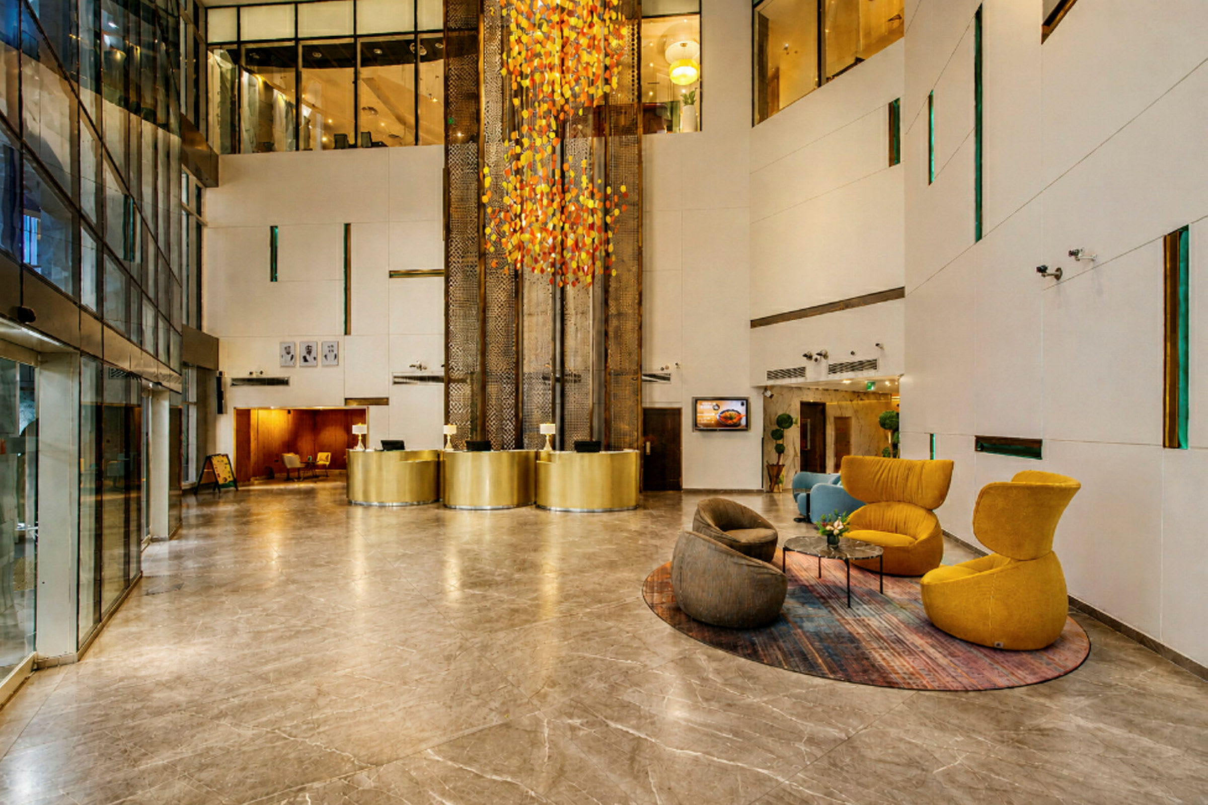 En hotellobby med marmorgolv, gyllene receptioner och färgglada sittmöbler. (AI-genererad text)