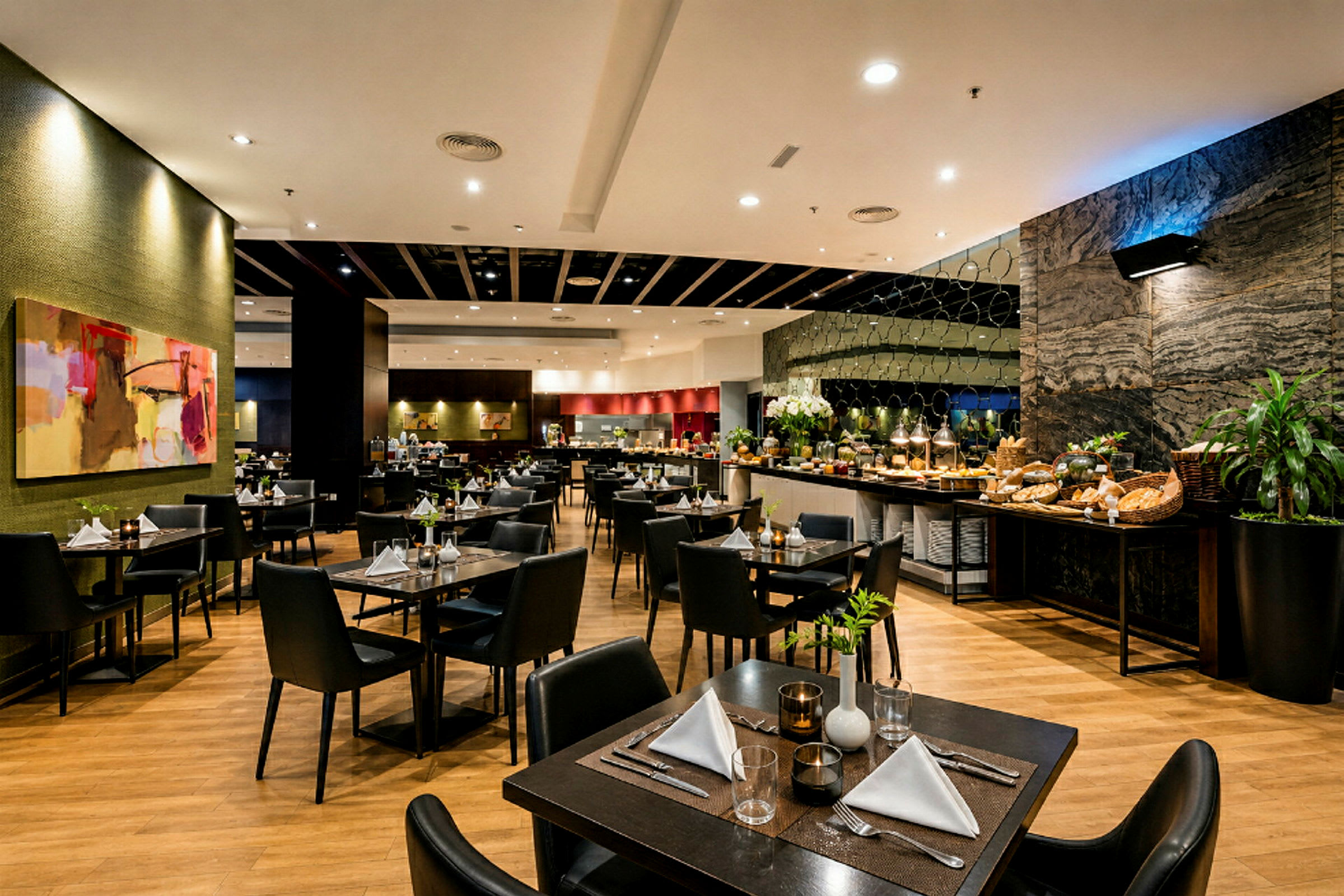 En restaurangsal med dukade bord och en buffé uppställd längs ena väggen. (AI-genererad text)