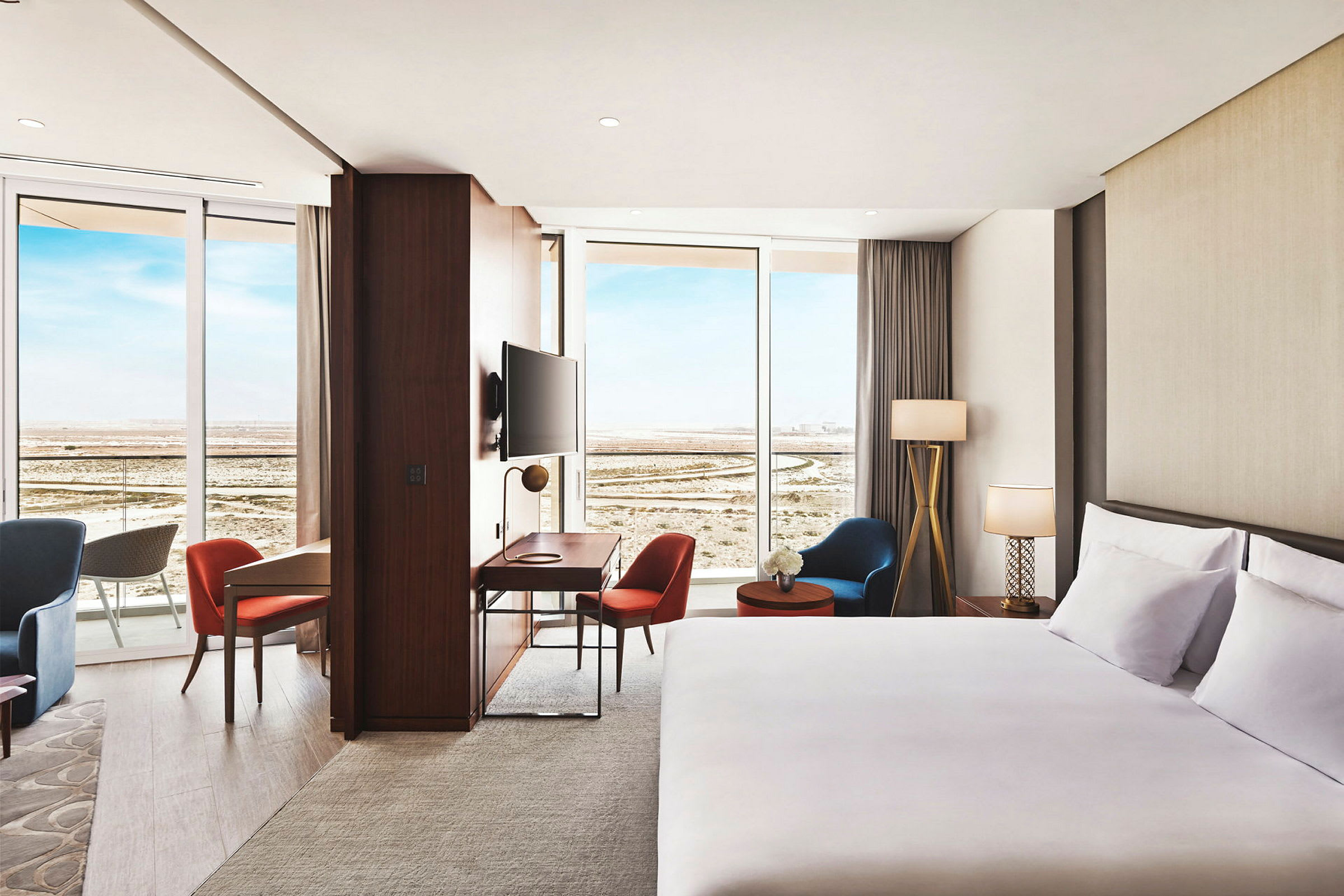 Bild av ett hotellrum med en dubbelsäng, sittmöbler och ett skrivbord samt stora fönster med utsikt. (AI-genererad text)