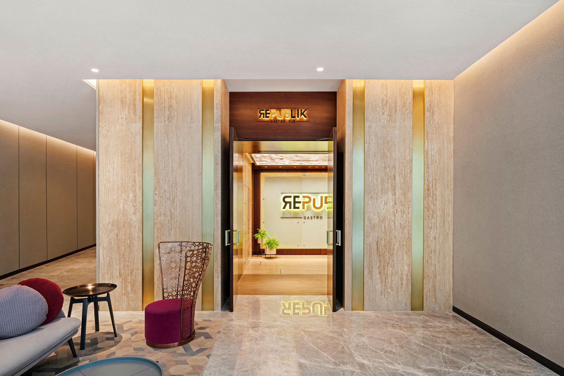 Lobby med en modern inredning, inkluderar sittplatser och ingång till Republik Gastro Pub. (AI-genererad text)