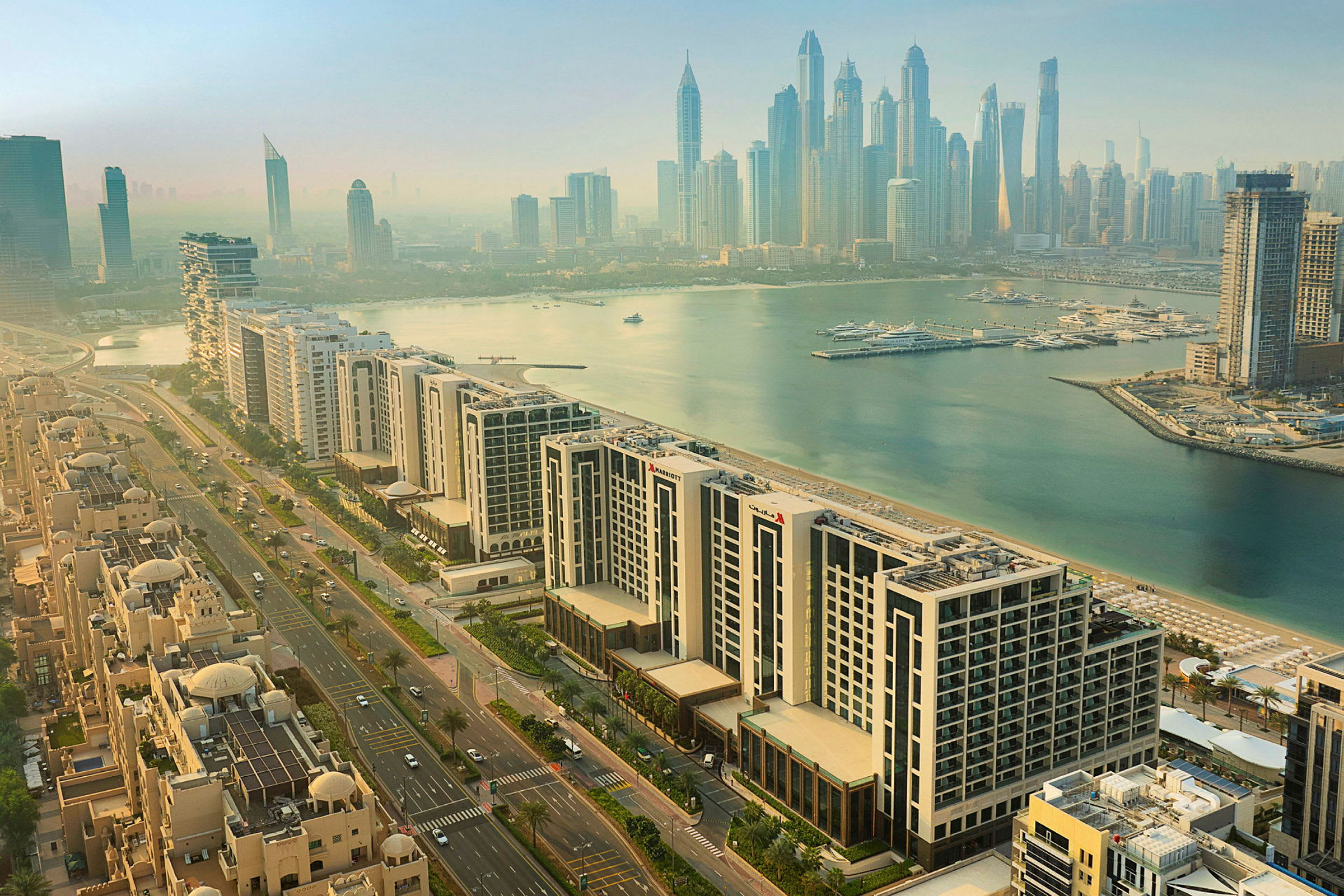 Luftig vy av Dubai Marina med moderna höghus, bostadsområden samt småbåtshamn vid vattnet. (AI-genererad text)
