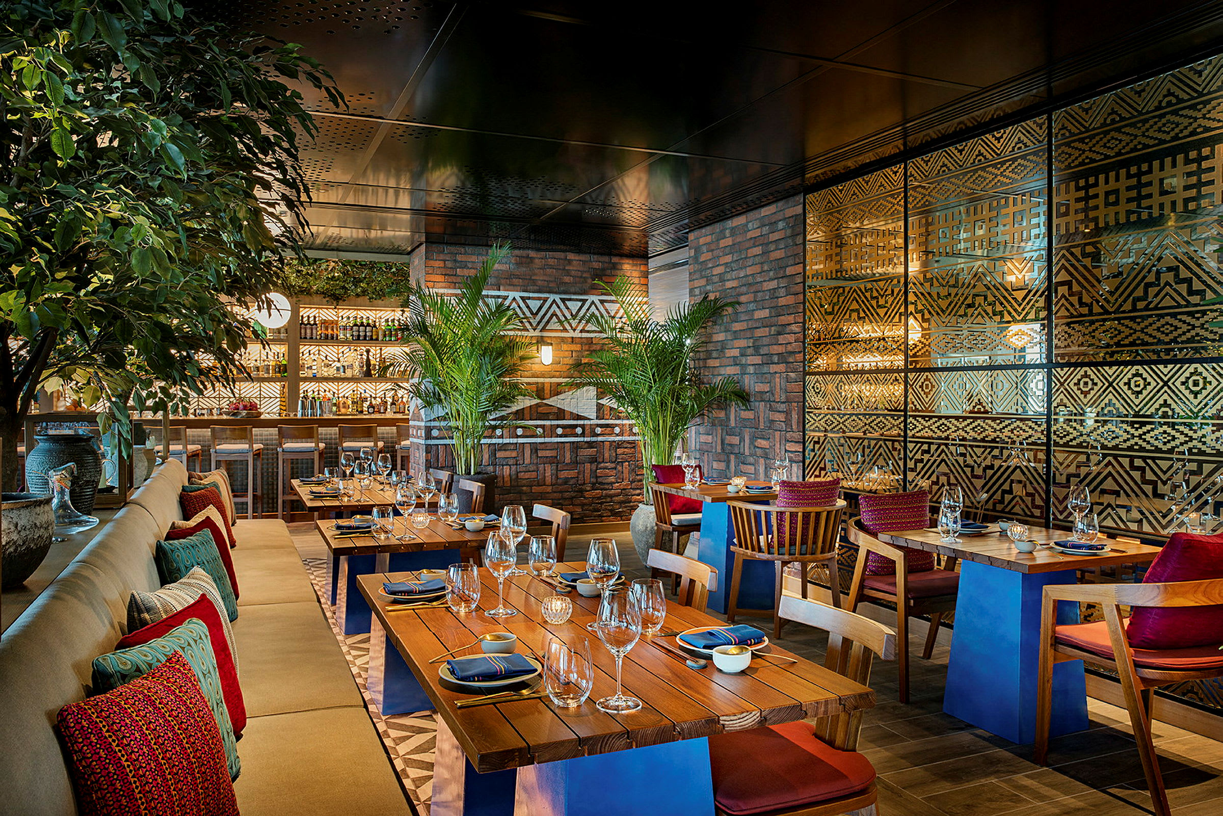 Interiör av en restaurang med träbord, stoppade stolar och dekorativ väggdesign. (AI-genererad text)