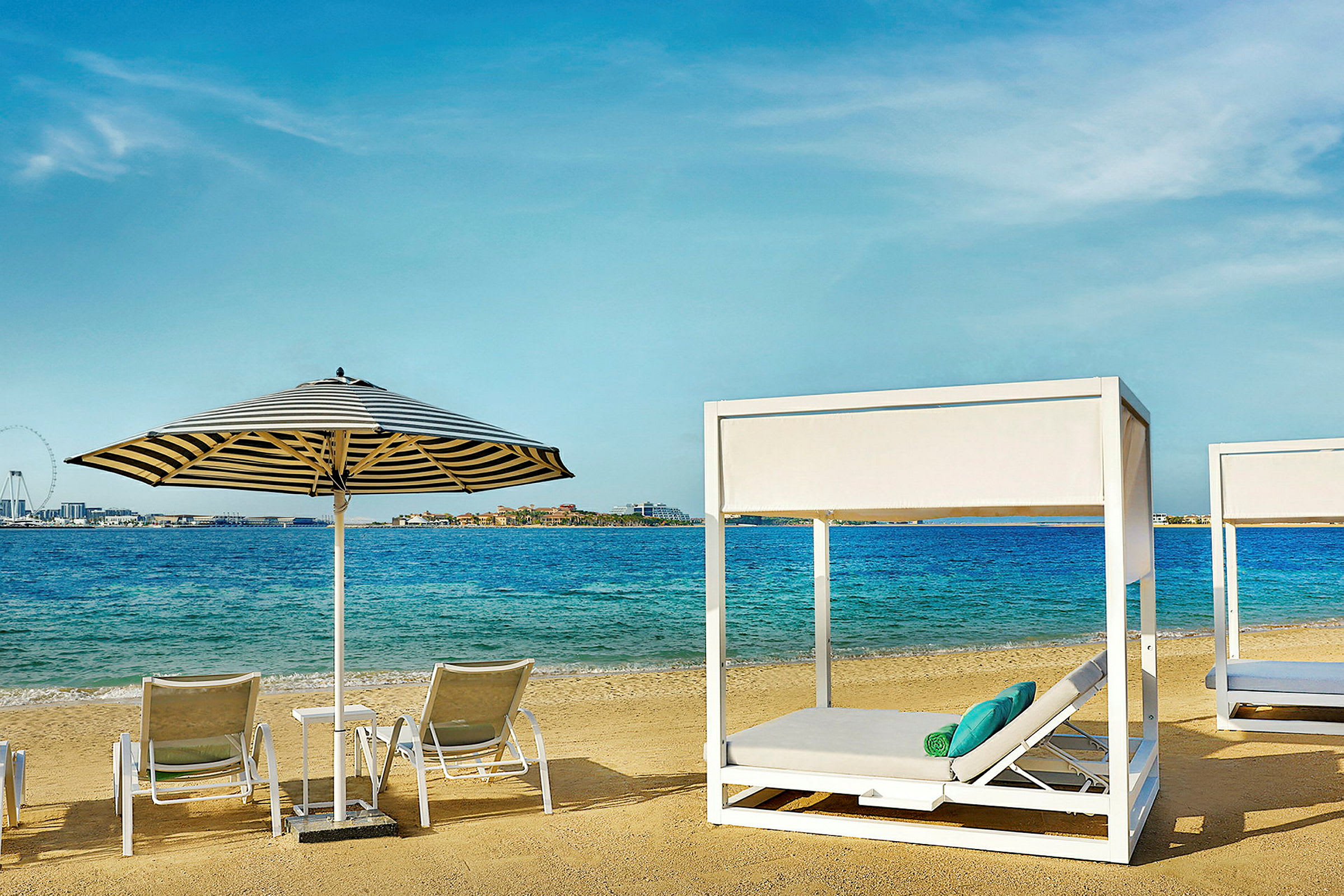 Strand med solstolar och parasoller framför havet. (AI-genererad text)