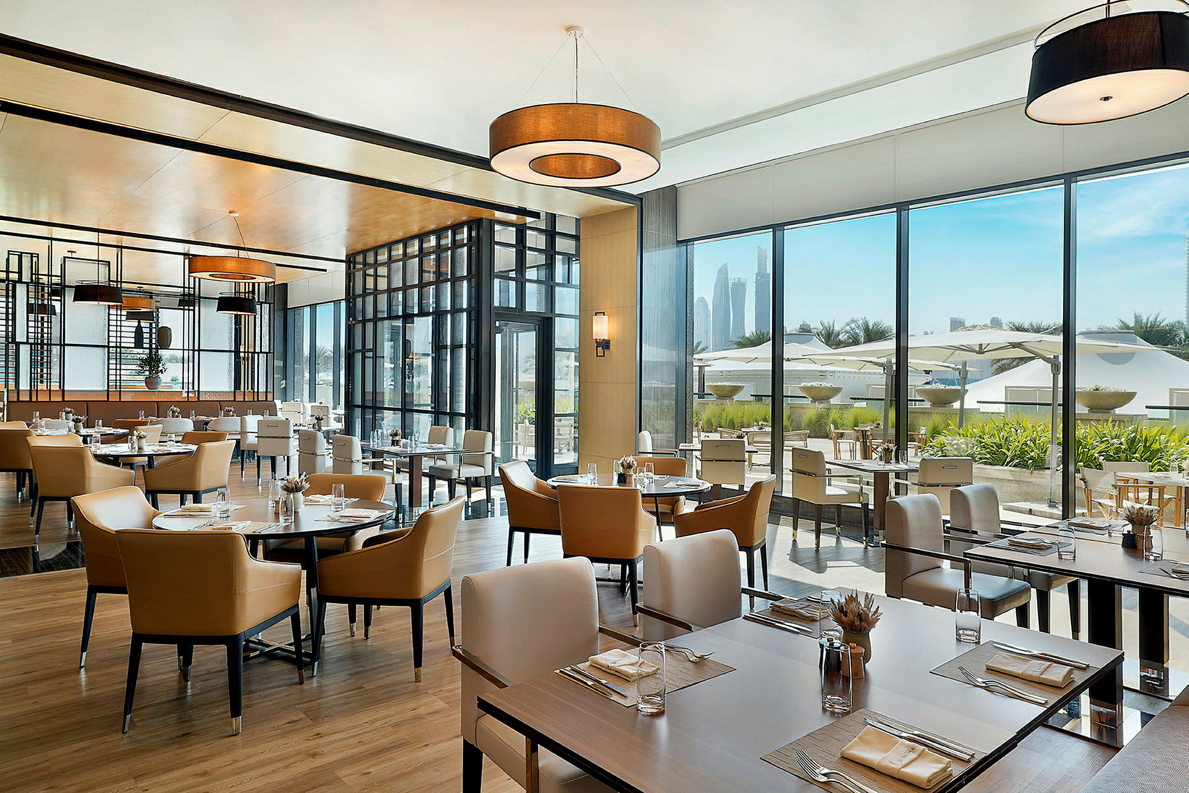 Modern restaurang med stora fönster och utsikt över utomhusområdet. (AI-genererad text)