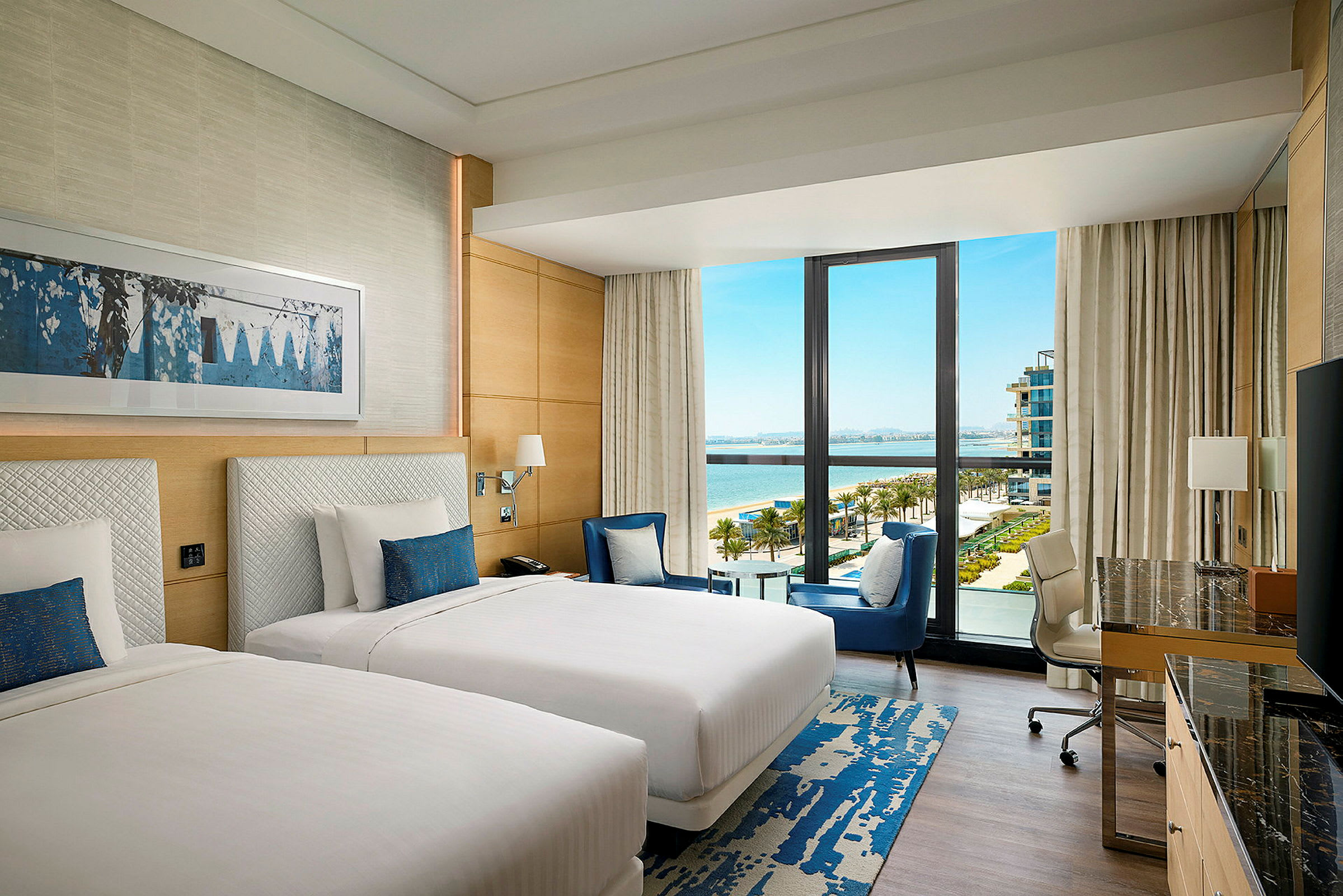 Ett hotellrum med två sängar, en stor glasvägg med utsikt mot en pool och havet. (AI-genererad text)