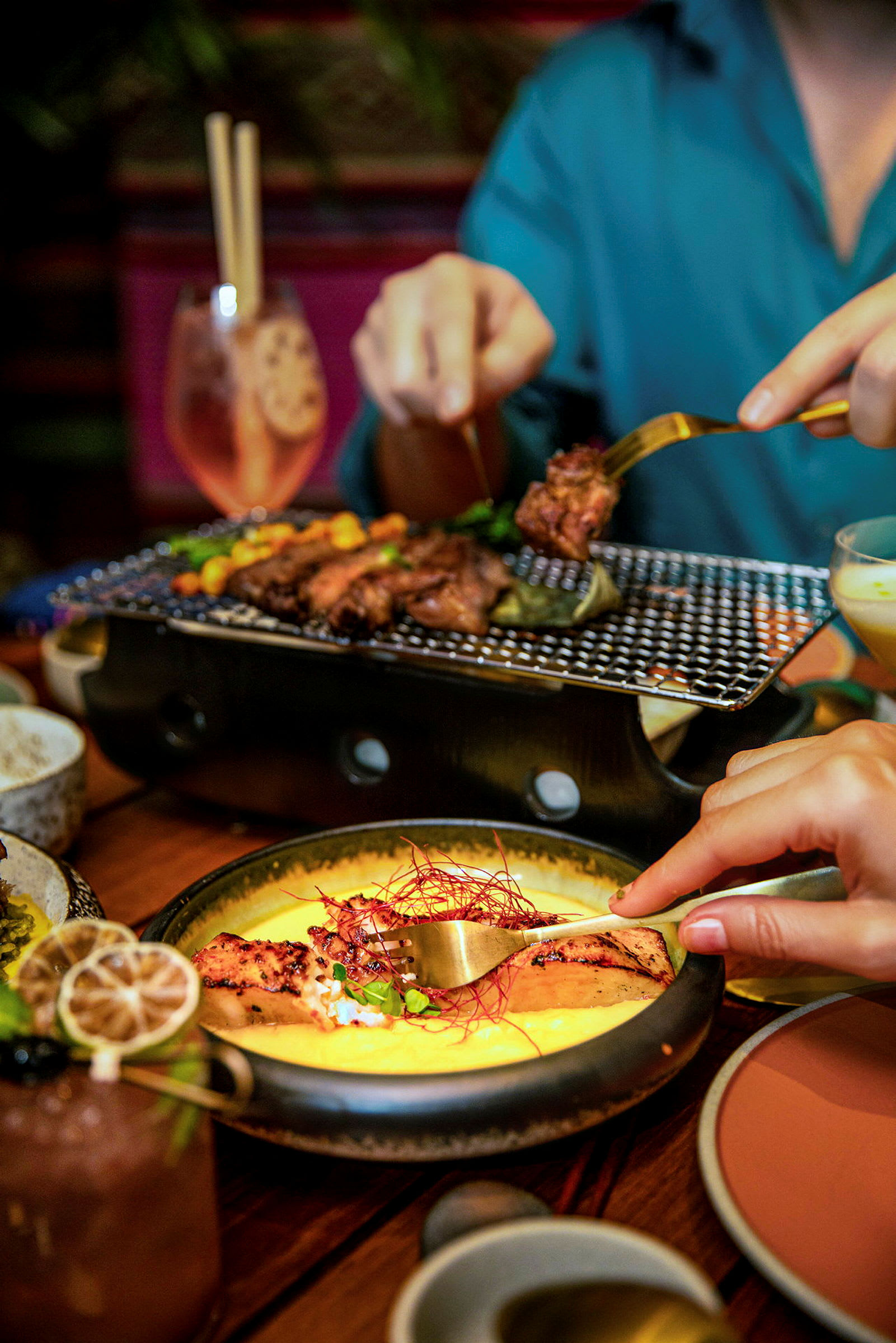Två personer delar på grillad mat vid ett bord. (AI-genererad text)
