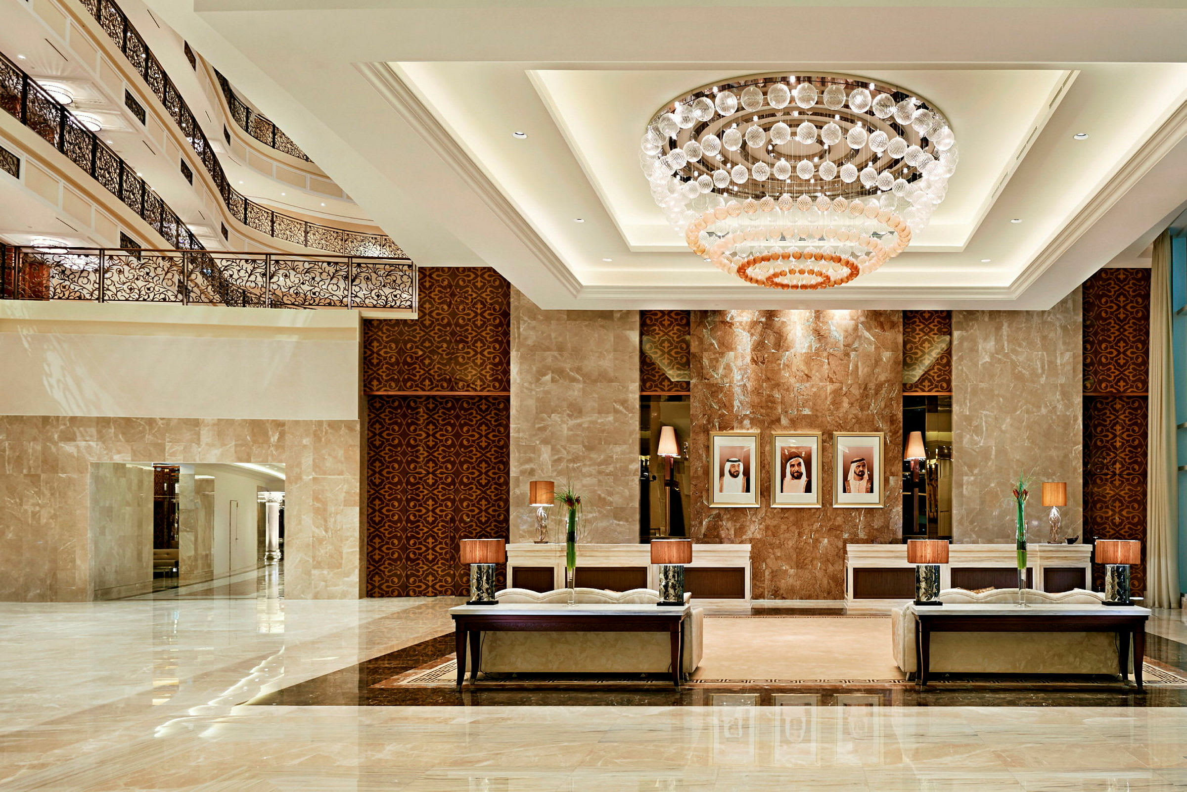 Ett elegant hotellobby med imponerande ljuskrona, marmorgolv och bekväma sittmöbler. (AI-genererad text)