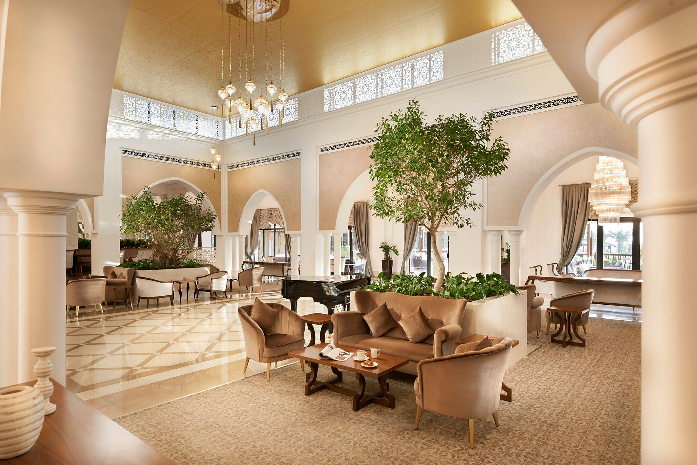 Ett elegant möblerat hotellobby med sittplatser, gröna växter och en flygel. (AI-genererad text)