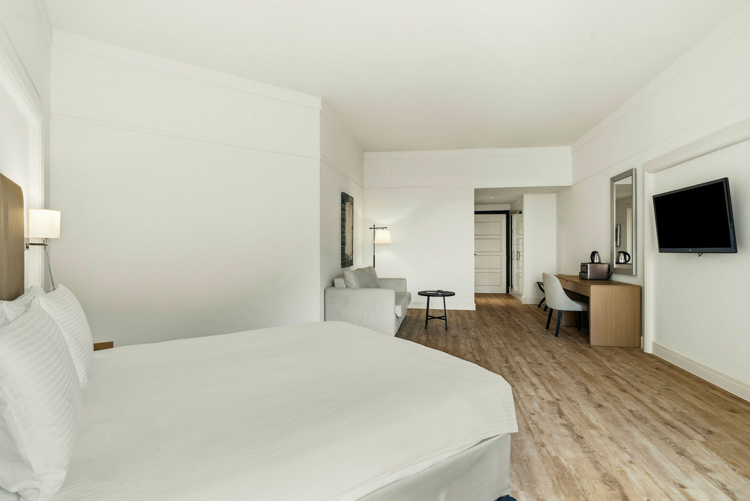 Ett hotellrum med en säng, en sittgrupp och ett skrivbord. (AI-genererad text)