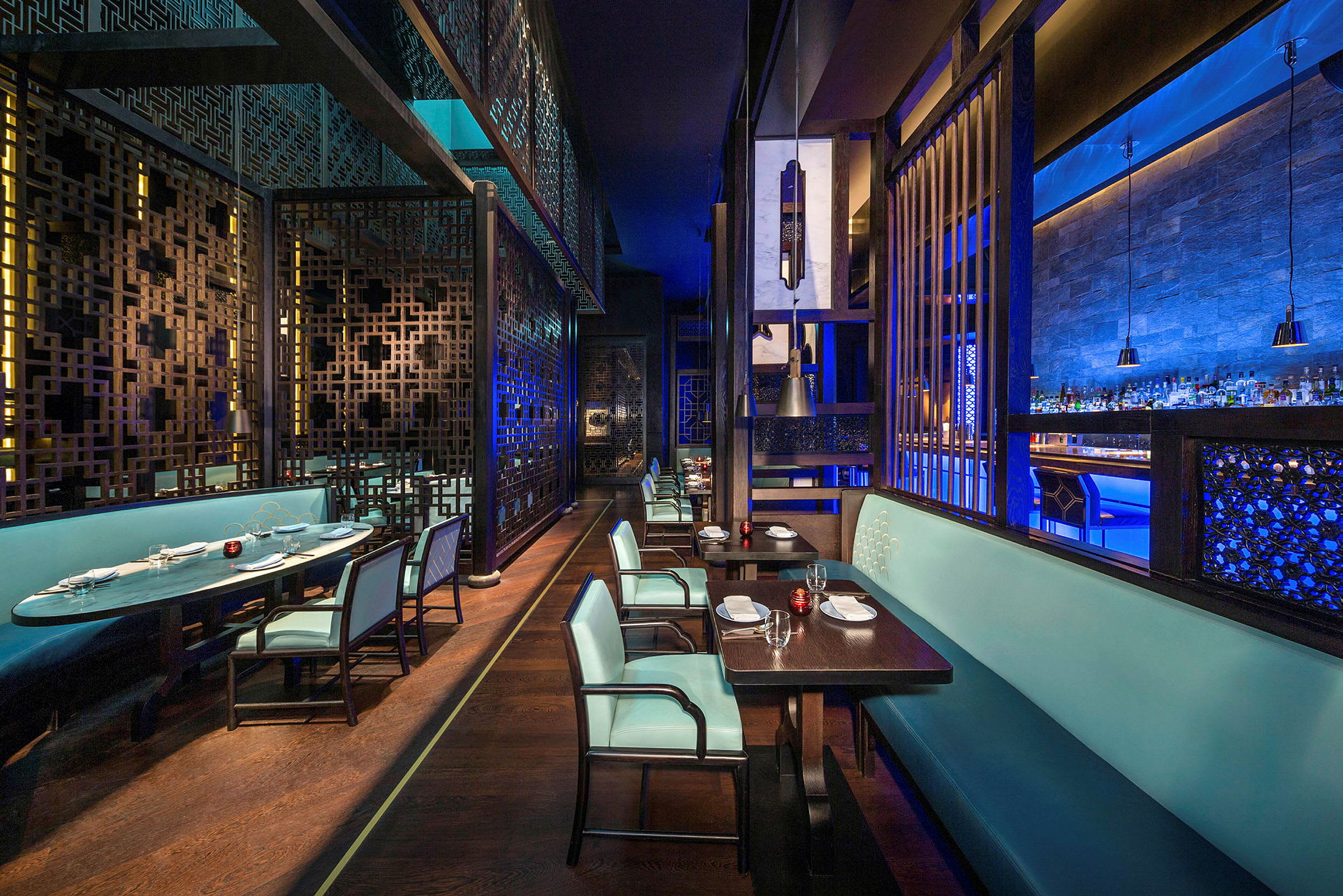 En interiör av en elegant restaurang med blå belysning och stilfulla möbler. (AI-genererad text)