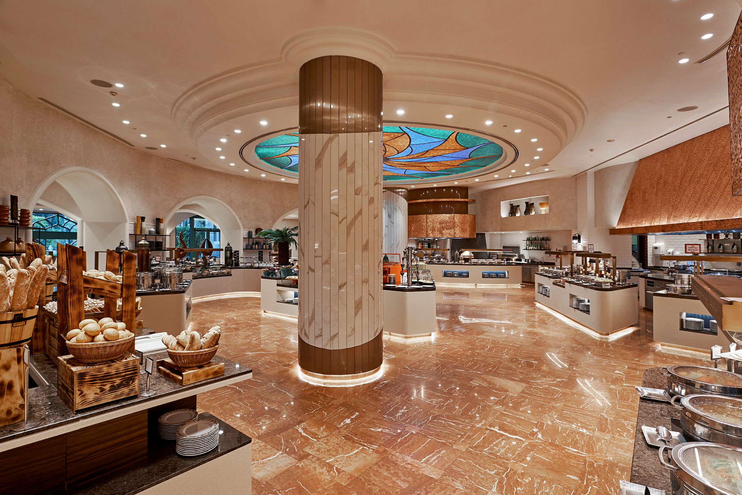 Buffématsal med bord, stolar och matstationer, väl upplyst med glasinlägg i taket. (AI-genererad text)
